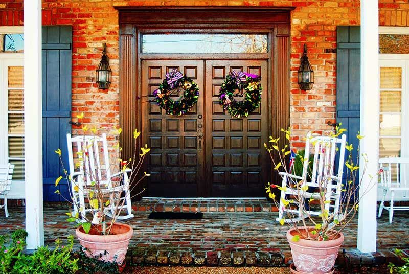 A front porch with rocking chairs and potted plants