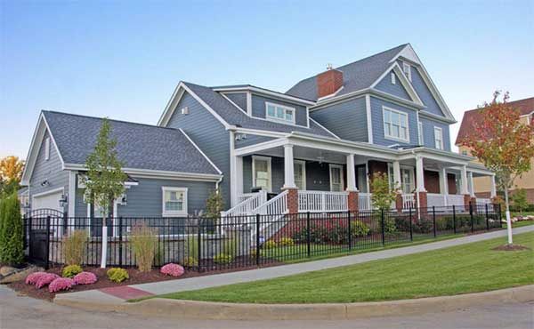 A large house with a large porch and a fence around it