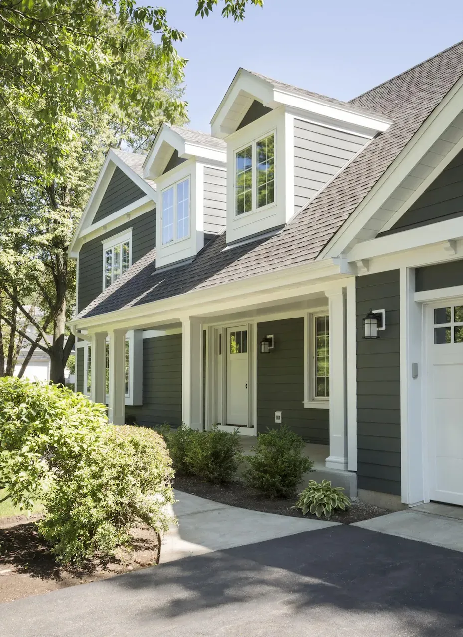 A large house with a large porch and a white garage door