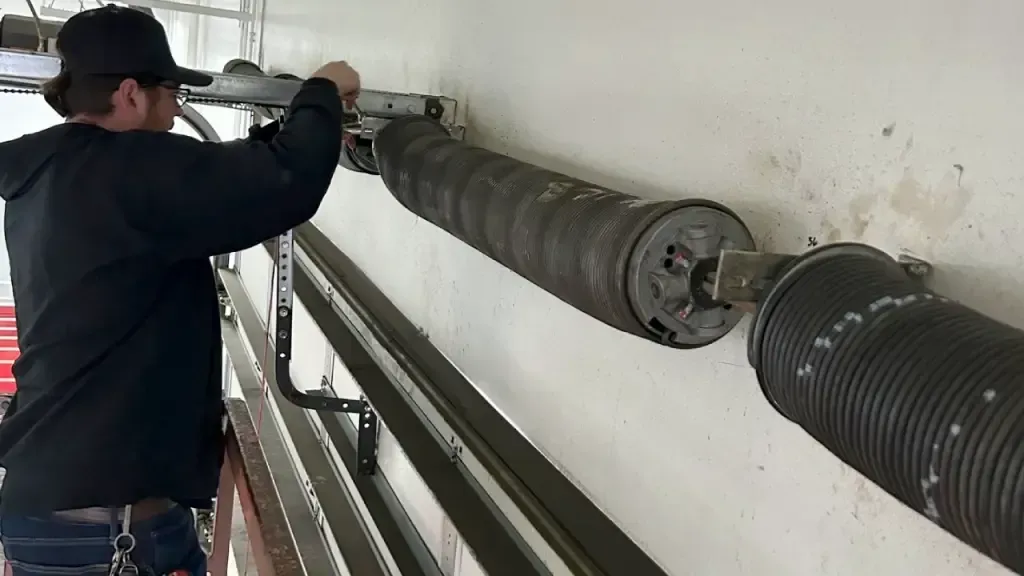 man working on a garage door spring