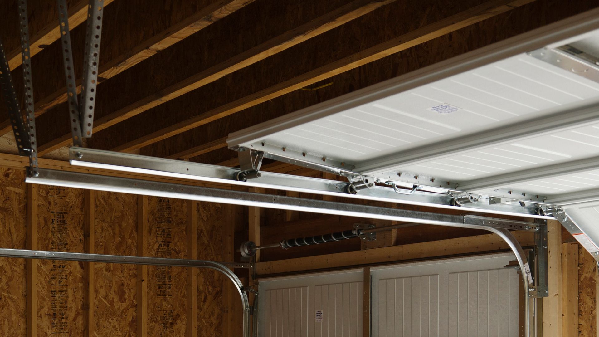 Garage door opener mechanism attached to garage ceiling.