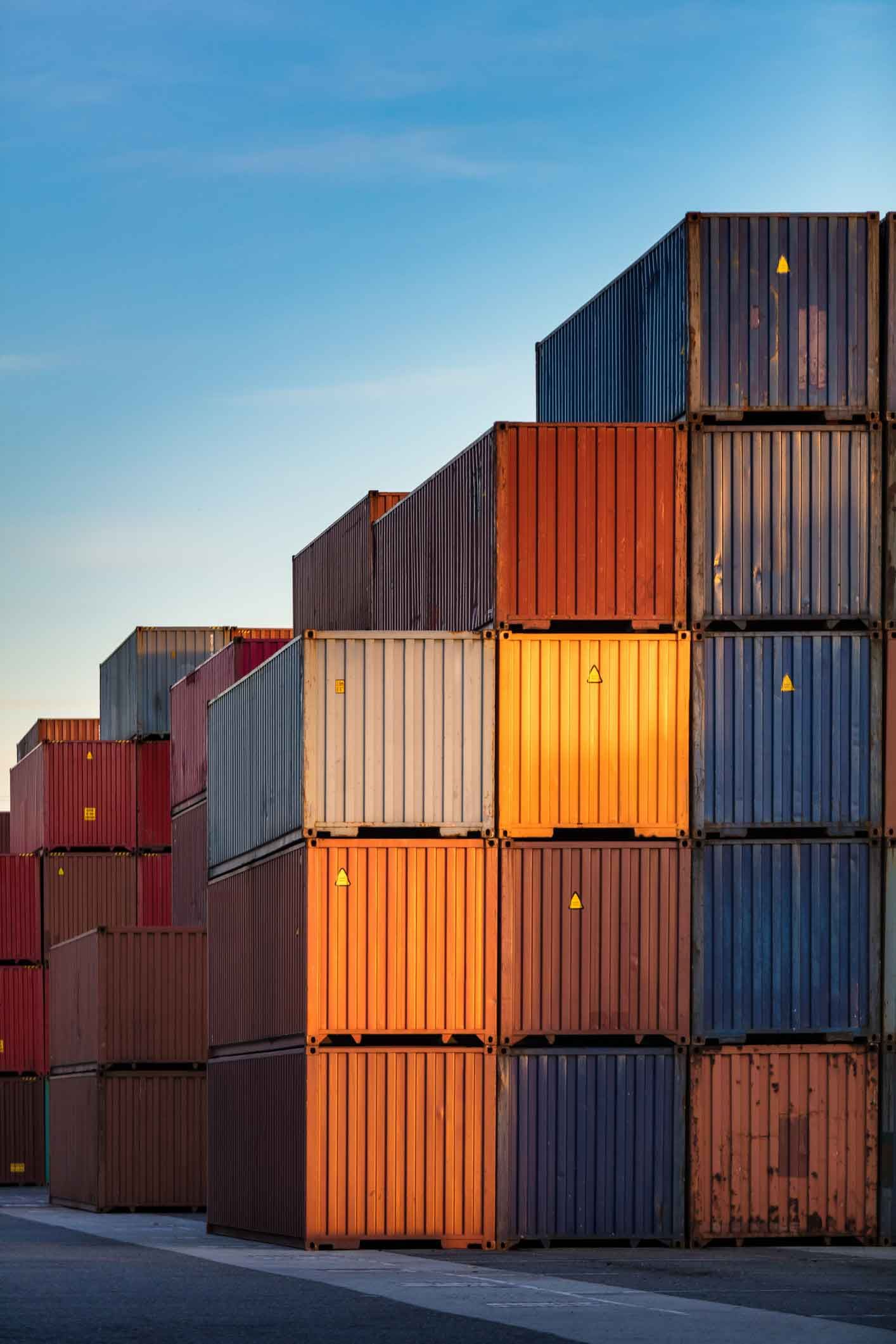 A row of shipping containers stacked on top of each other in a warehouse.