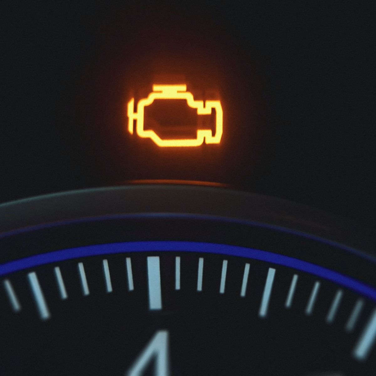 Dashboard with an illuminated orange engine warning light.