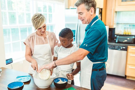 Foster parents and foster children cooking together.