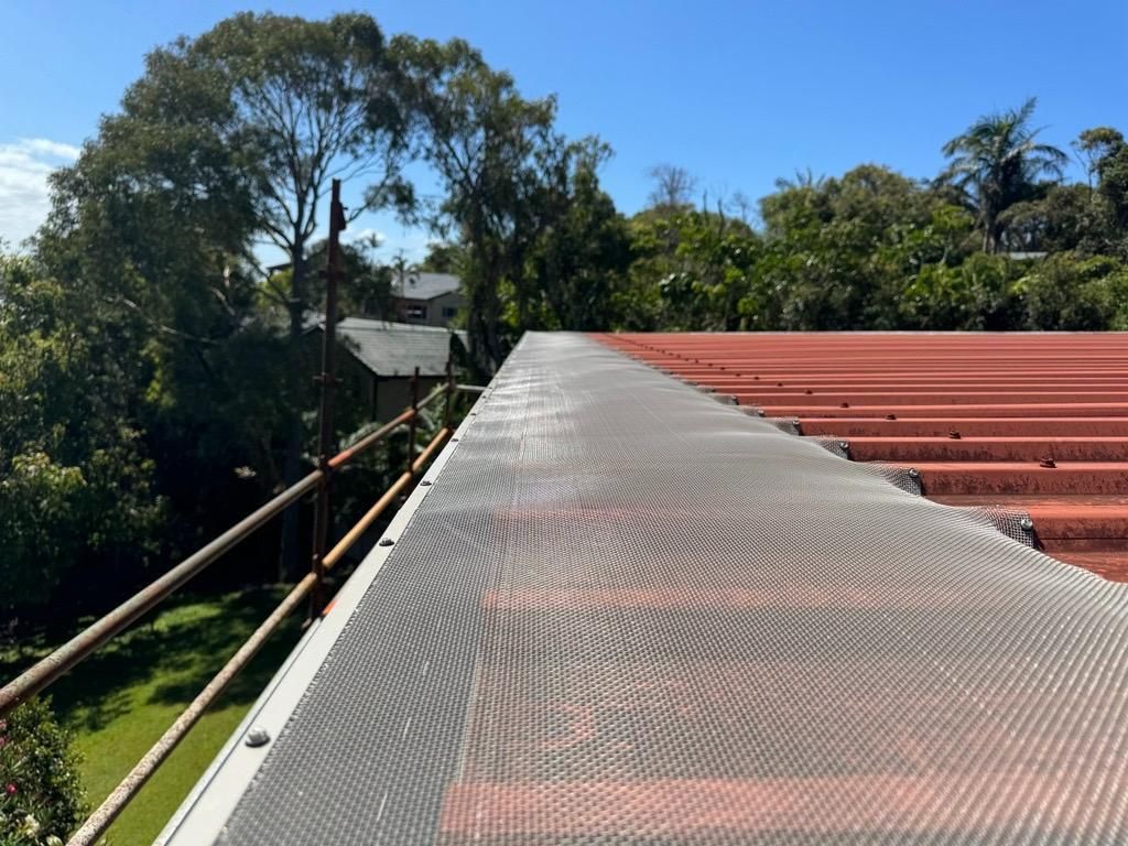 Plastic Guard Over Gutter On A Roof With A Leaf Stuck — Gutter Guards In Lismore NSW