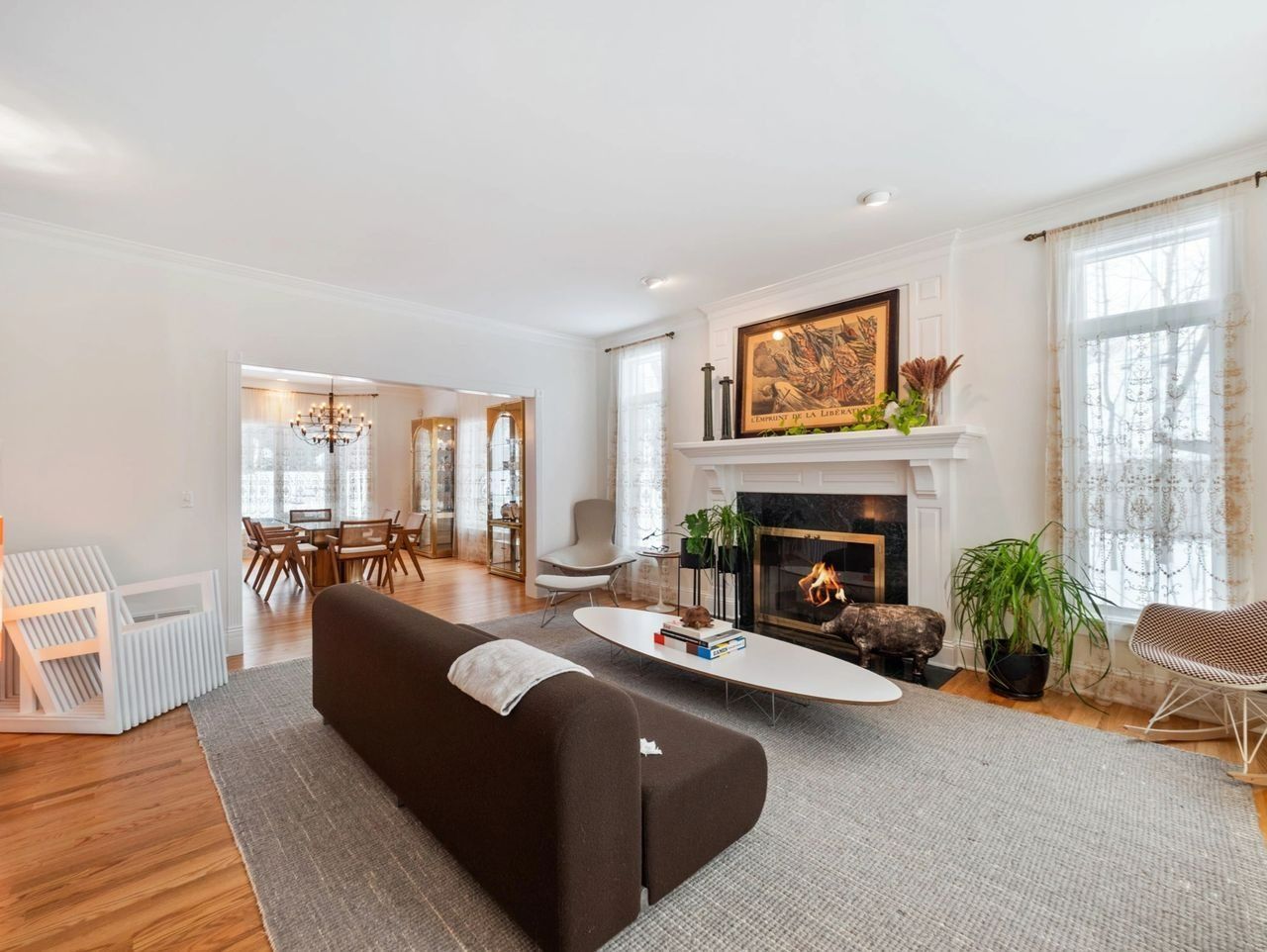 Living room with fireplace, brown sofa, and dining area visible in the background.