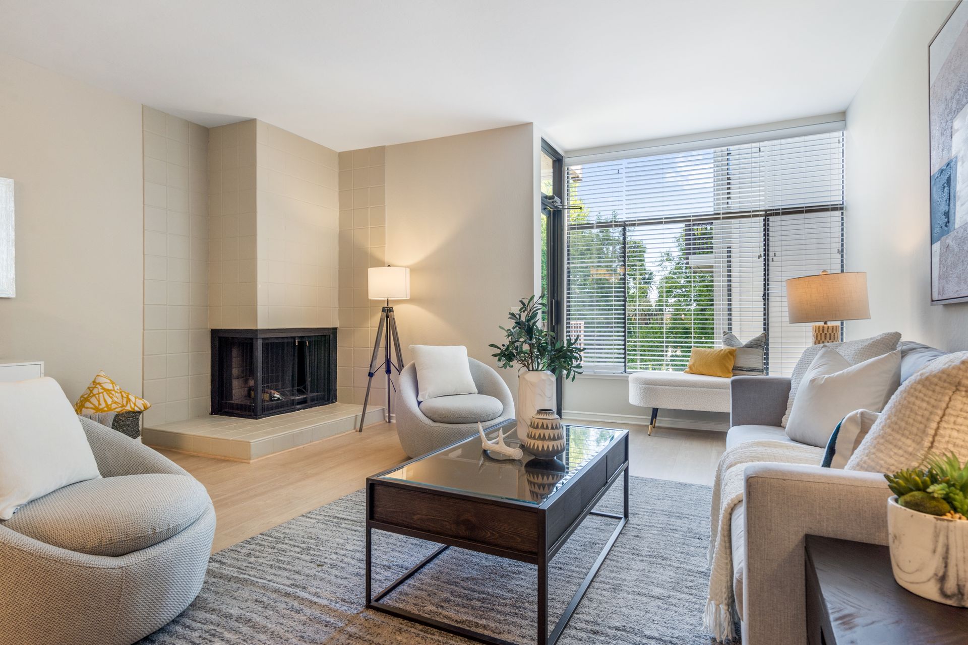 A living room with a couch , chair , coffee table and fireplace.
