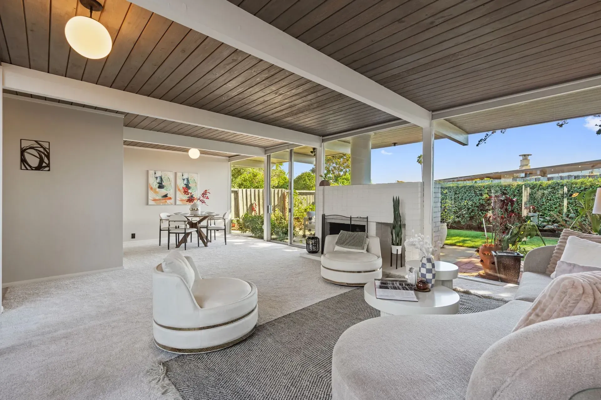A living room with white furniture and a fireplace