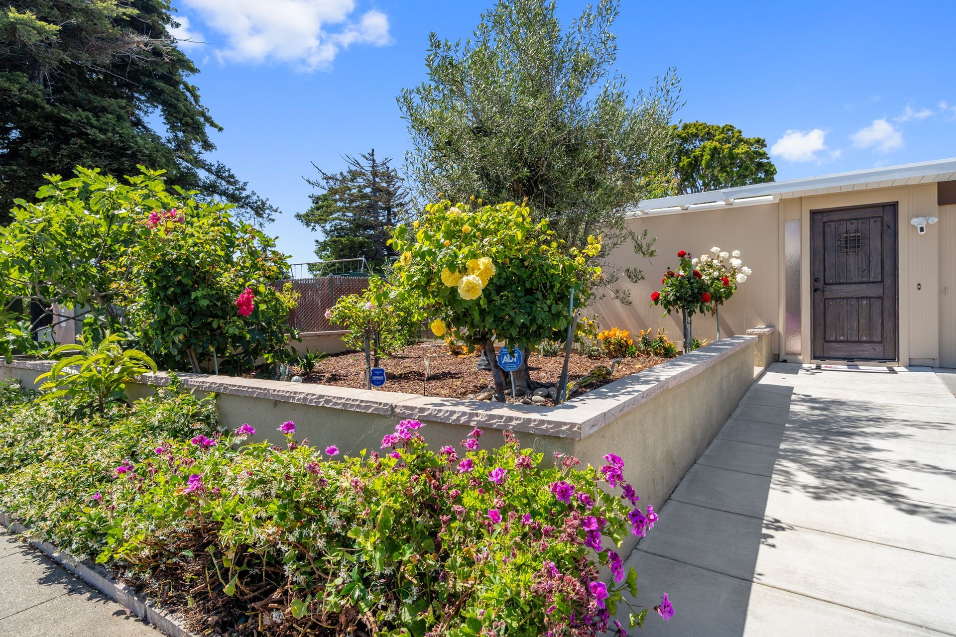 A house with a fence and flowers in front of it