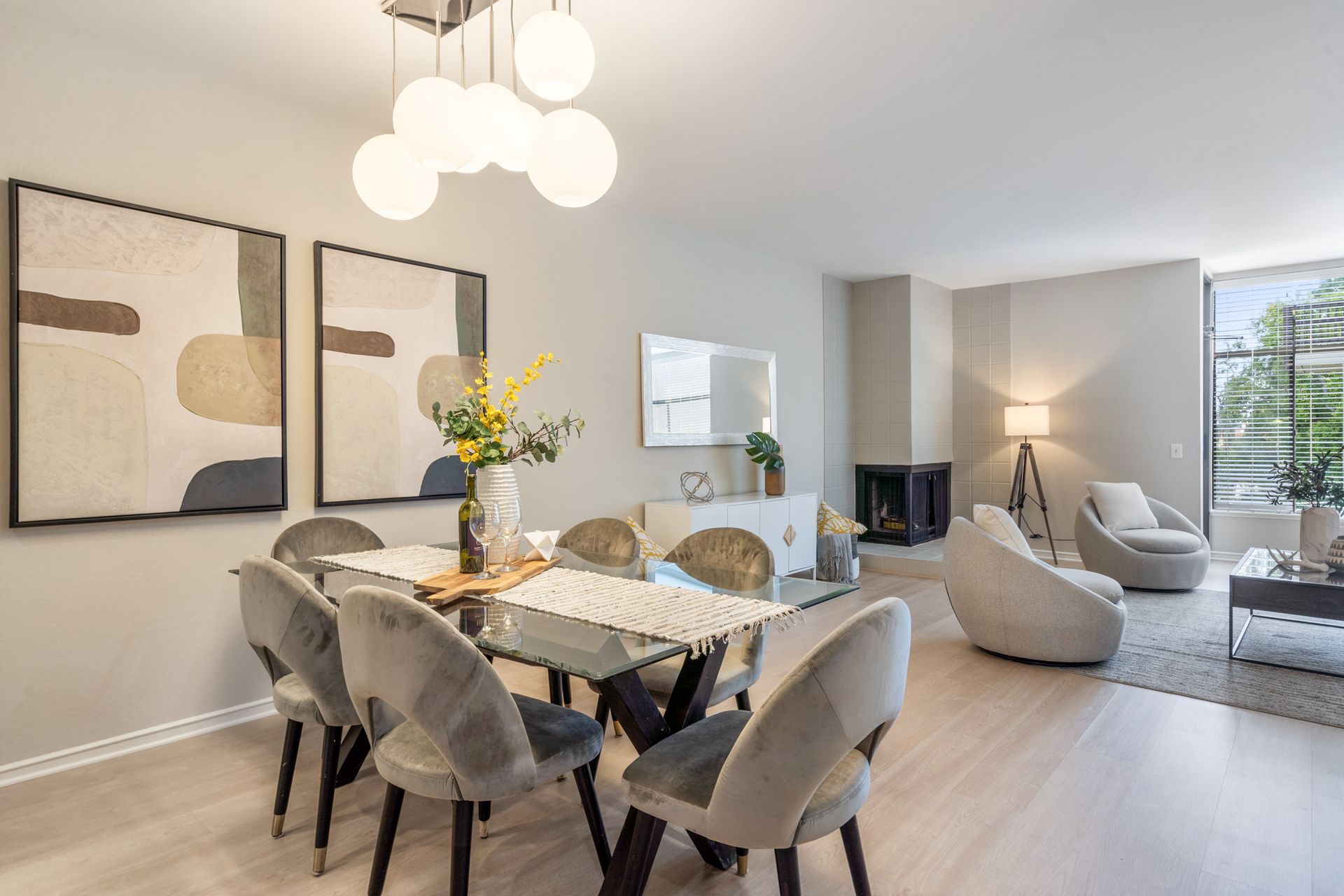 A living room with a dining table and chairs and a fireplace.