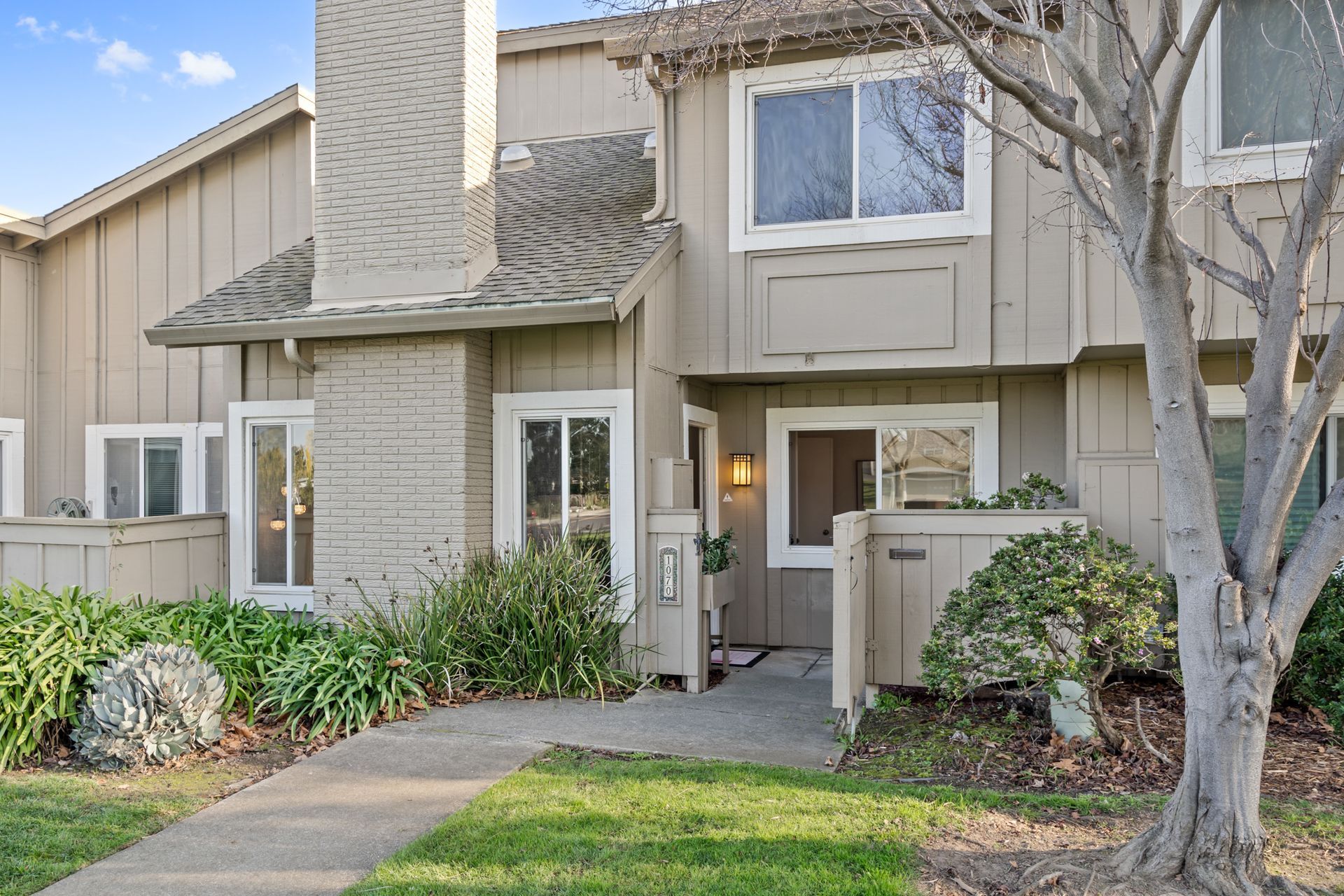 The front of a house with a tree in front of it