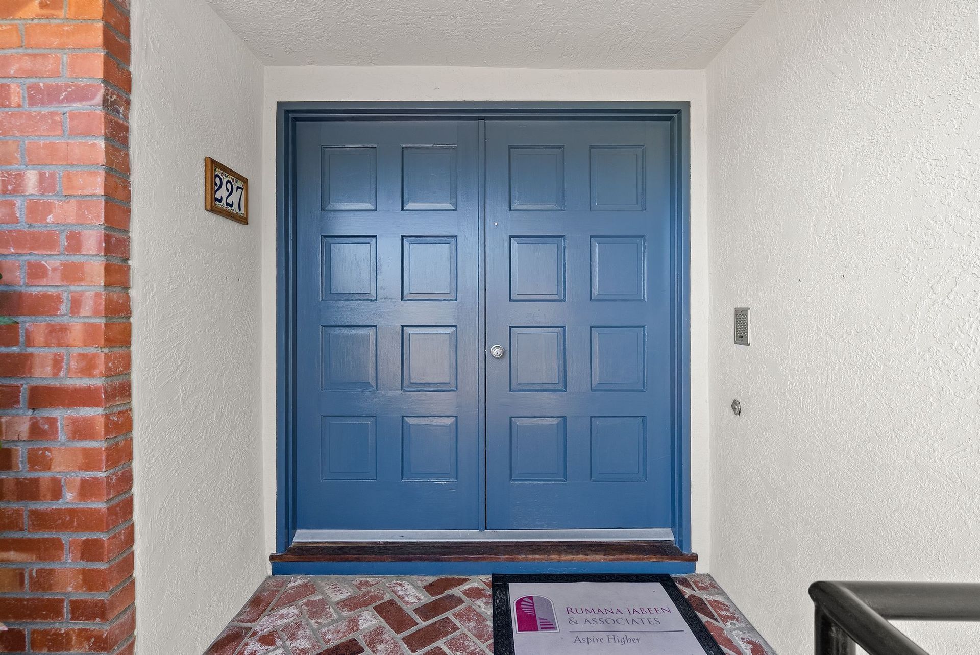 A blue double door with a brick wall behind it
