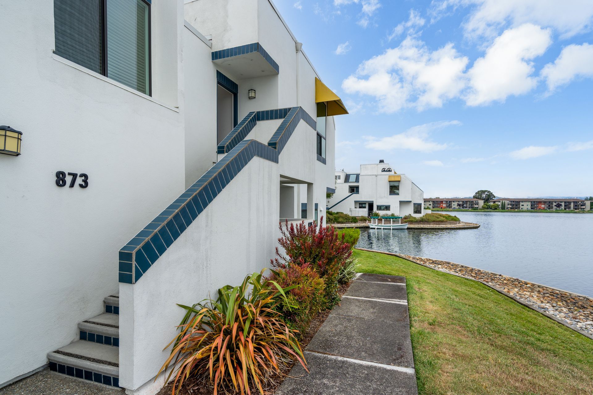 A white building with stairs leading up to the front door.