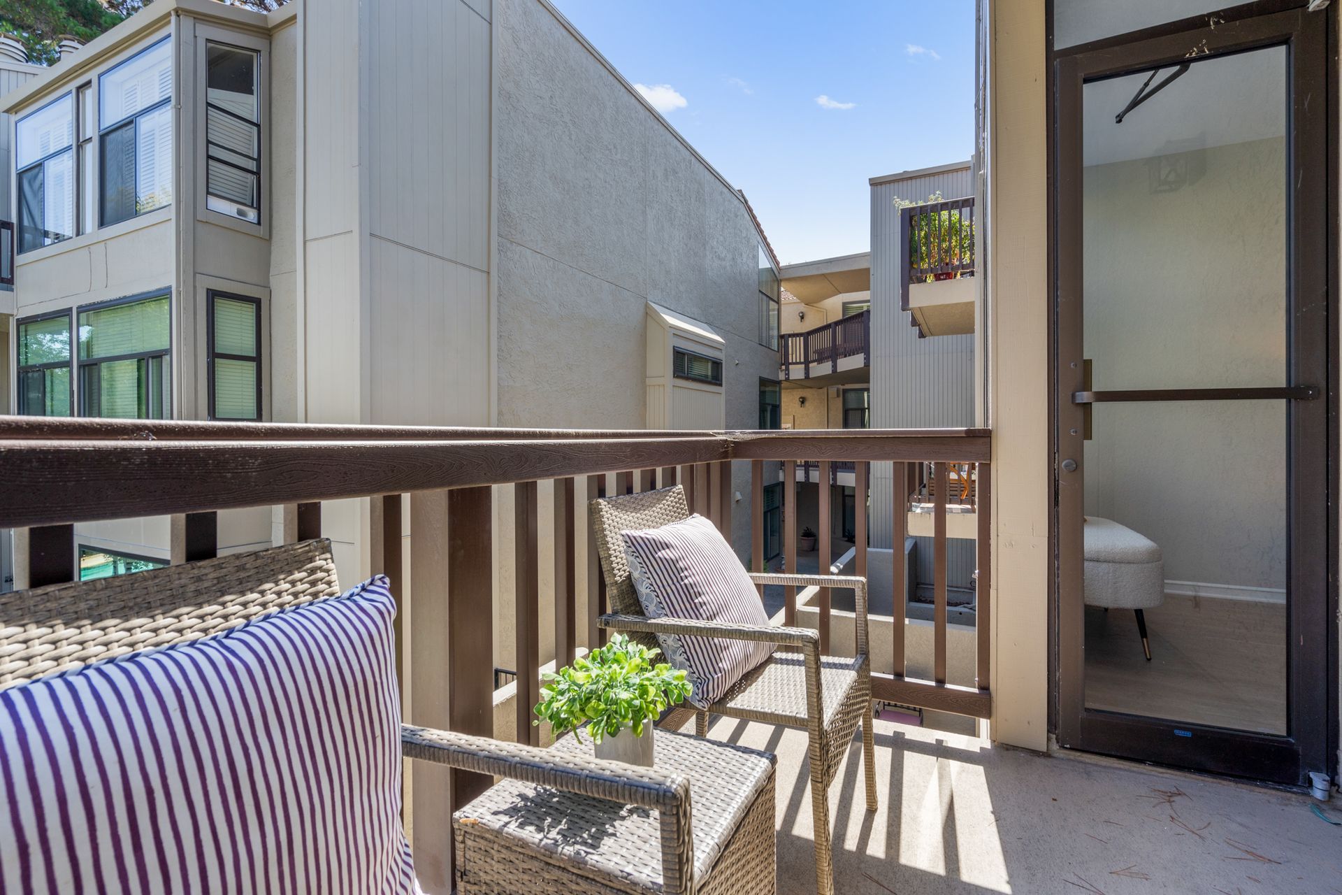 There is a balcony with a table and chairs on it.