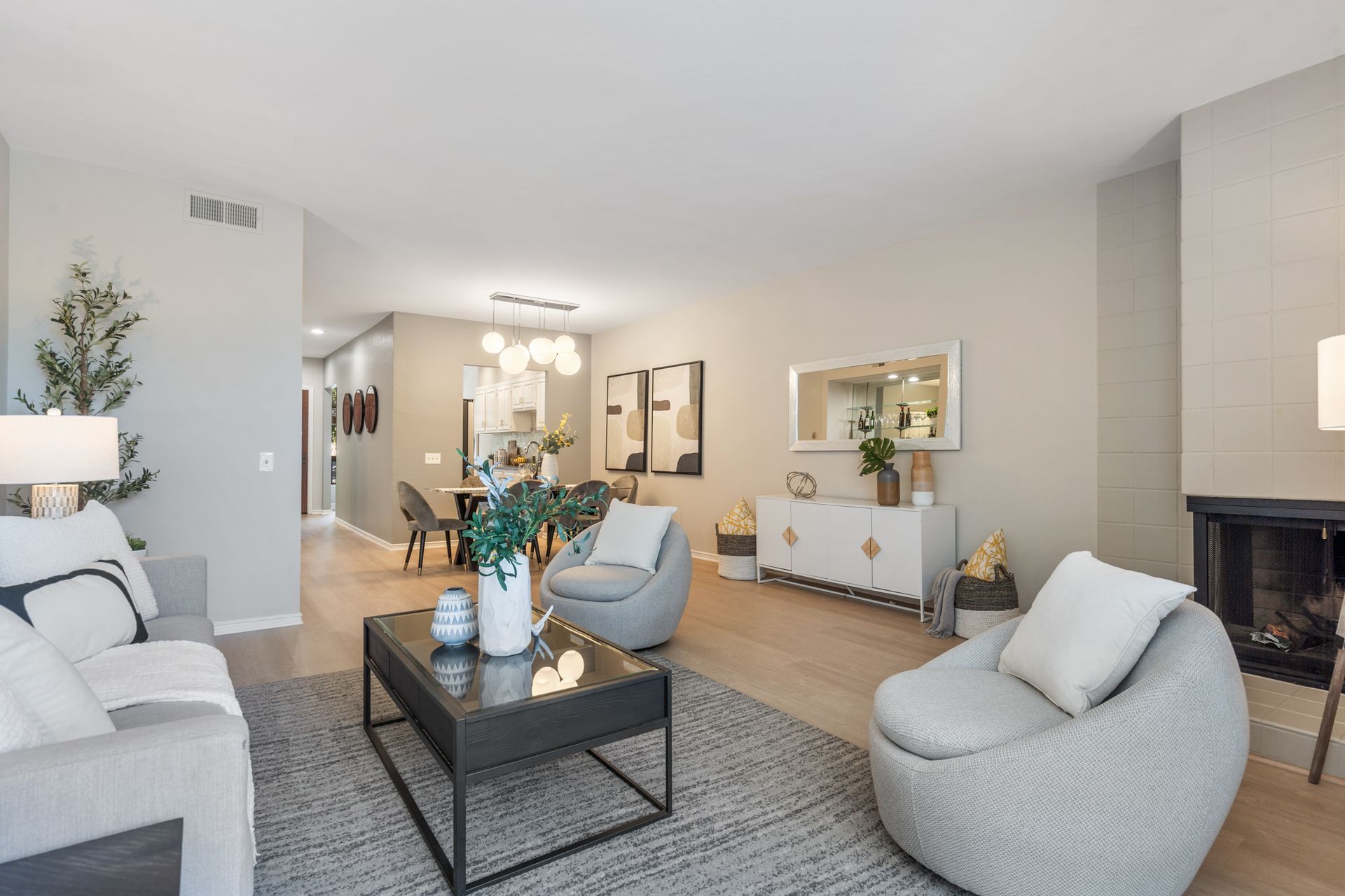 A living room with a couch , chair , coffee table and fireplace.