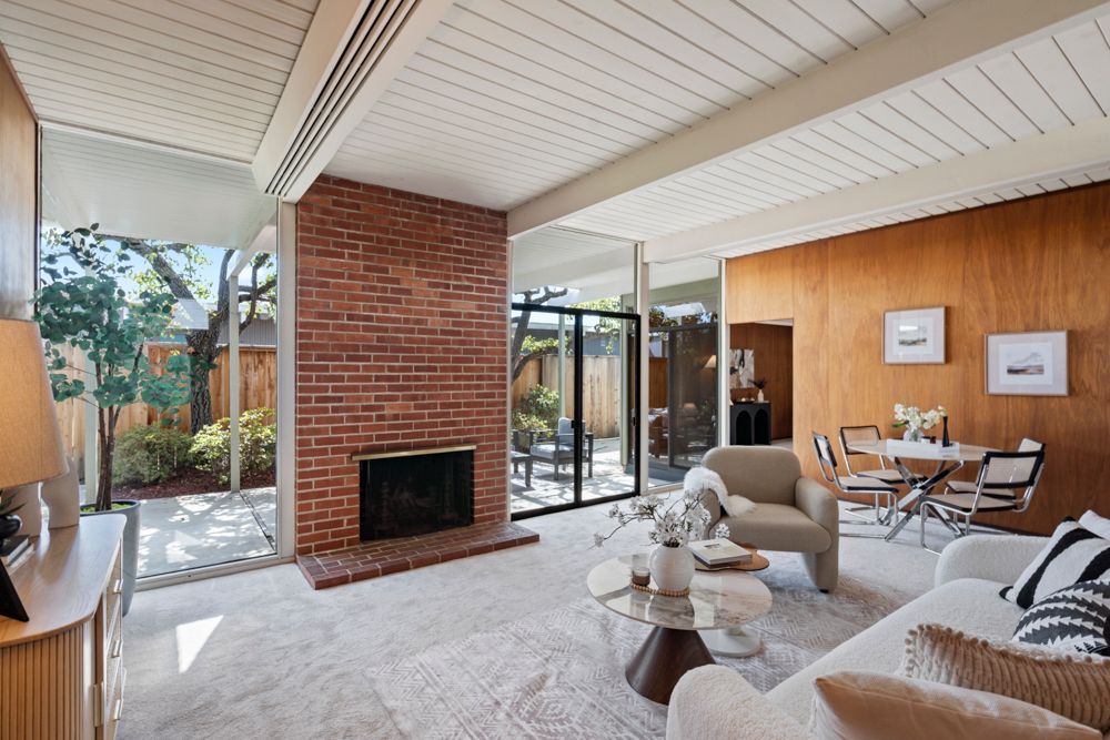 Open living and dining room with natural light, fireplace, and glass doors — Rumana Jabeen & Associates highlight flow and atmosphere buyers value and sellers can showcase.