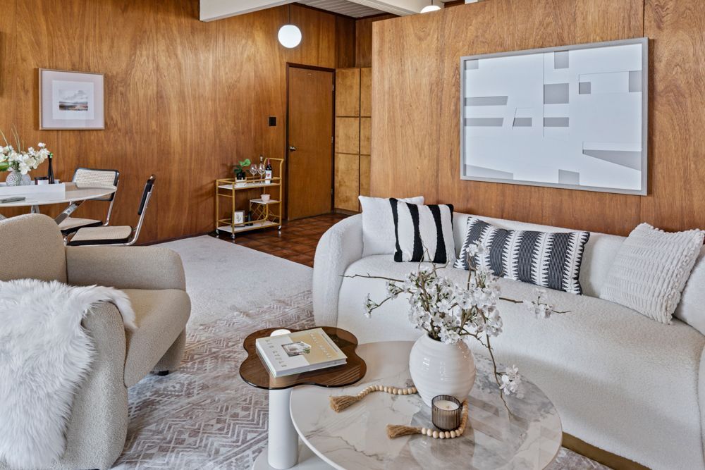 Open living and dining room with natural light, fireplace, and glass doors — Rumana Jabeen & Associates highlight flow and atmosphere buyers value and sellers can showcase.