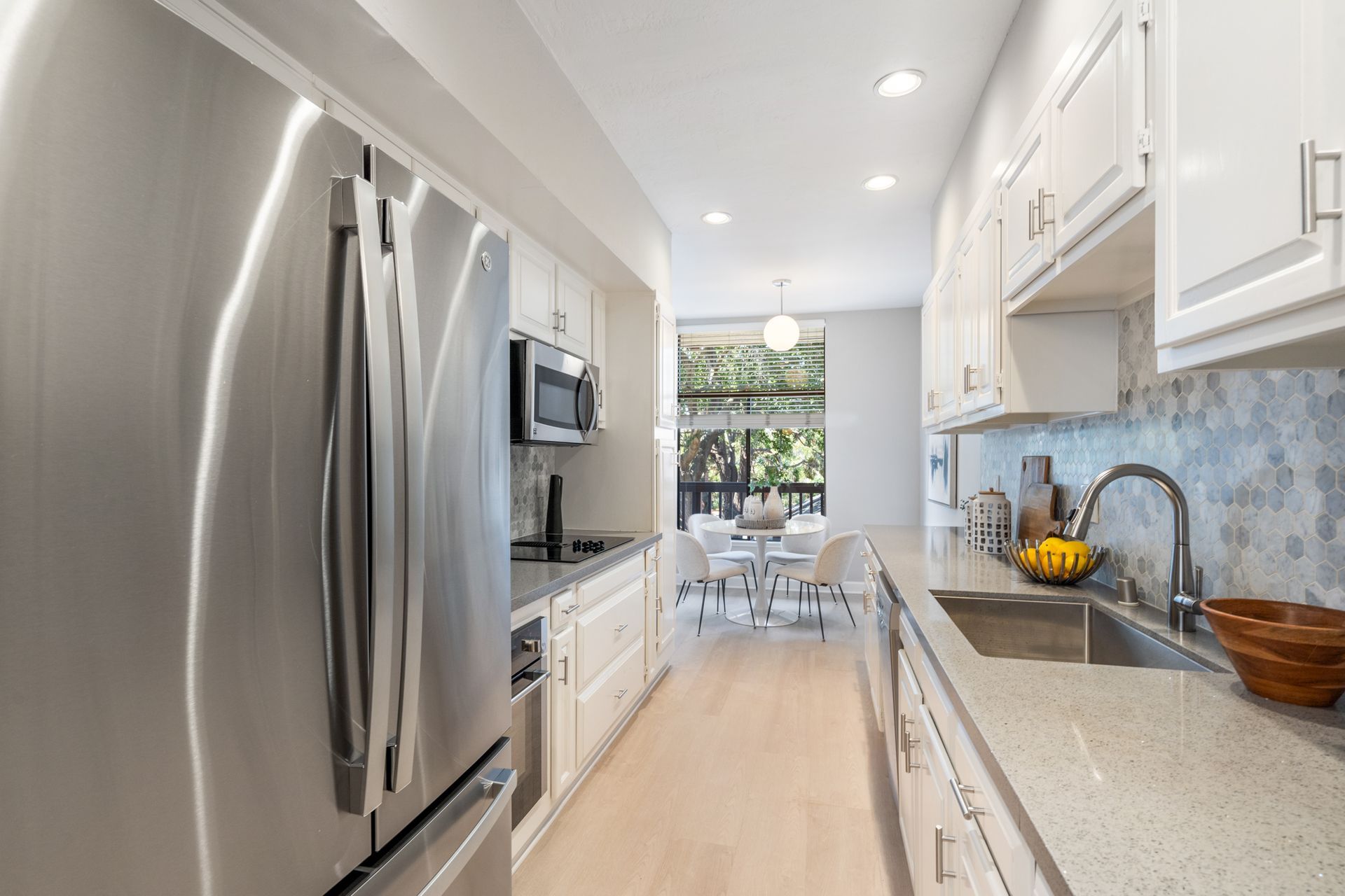 A kitchen with stainless steel appliances and white cabinets.
