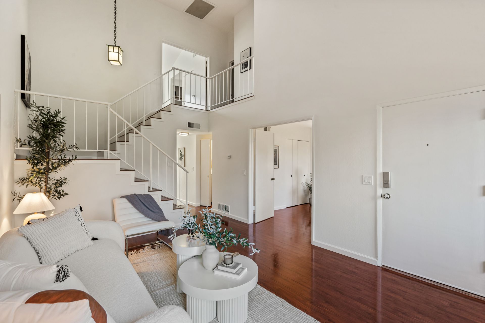 A living room with a staircase leading up to the second floor.