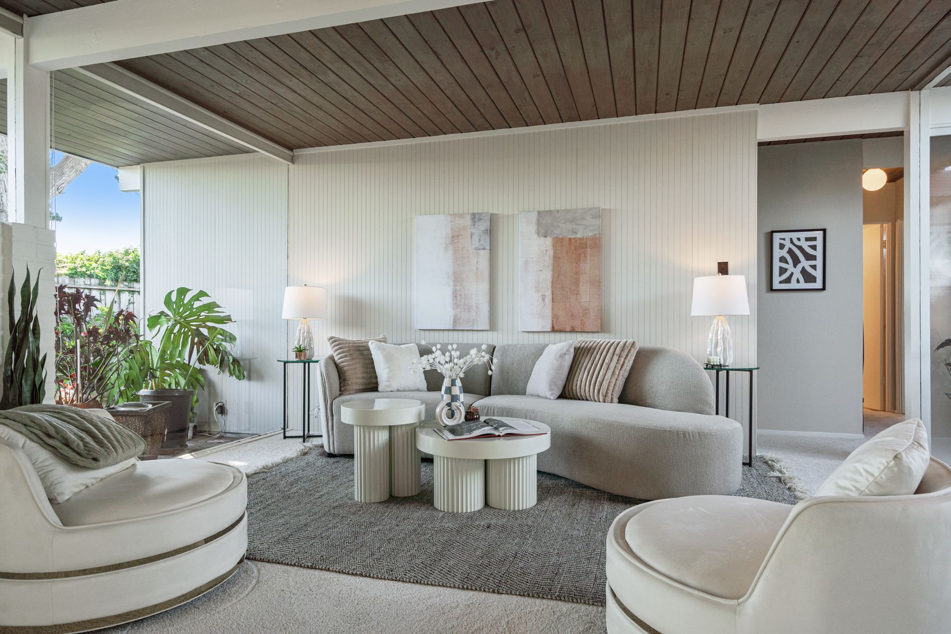 A living room with a couch , chairs , and a coffee table.