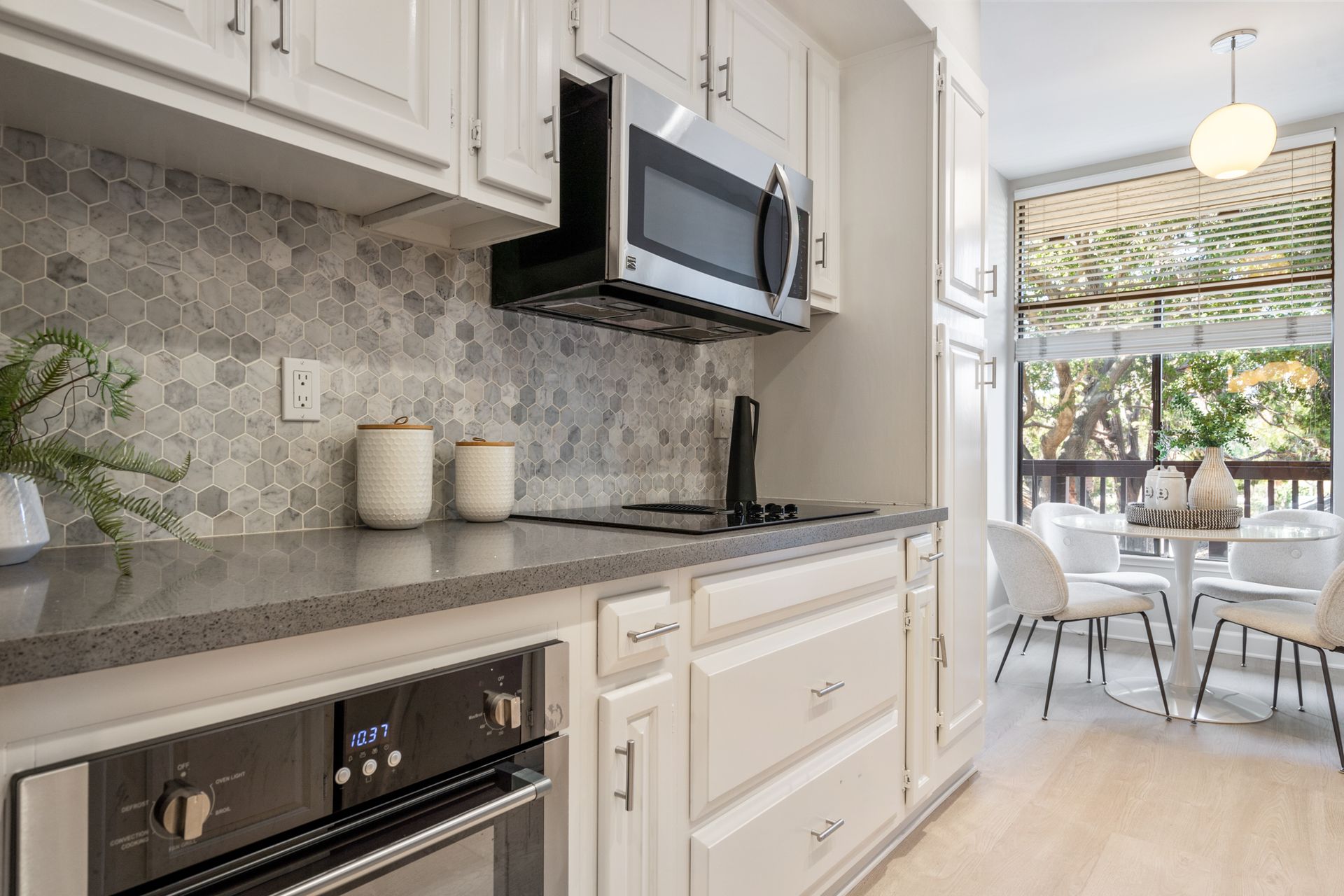 A kitchen with white cabinets and stainless steel appliances.