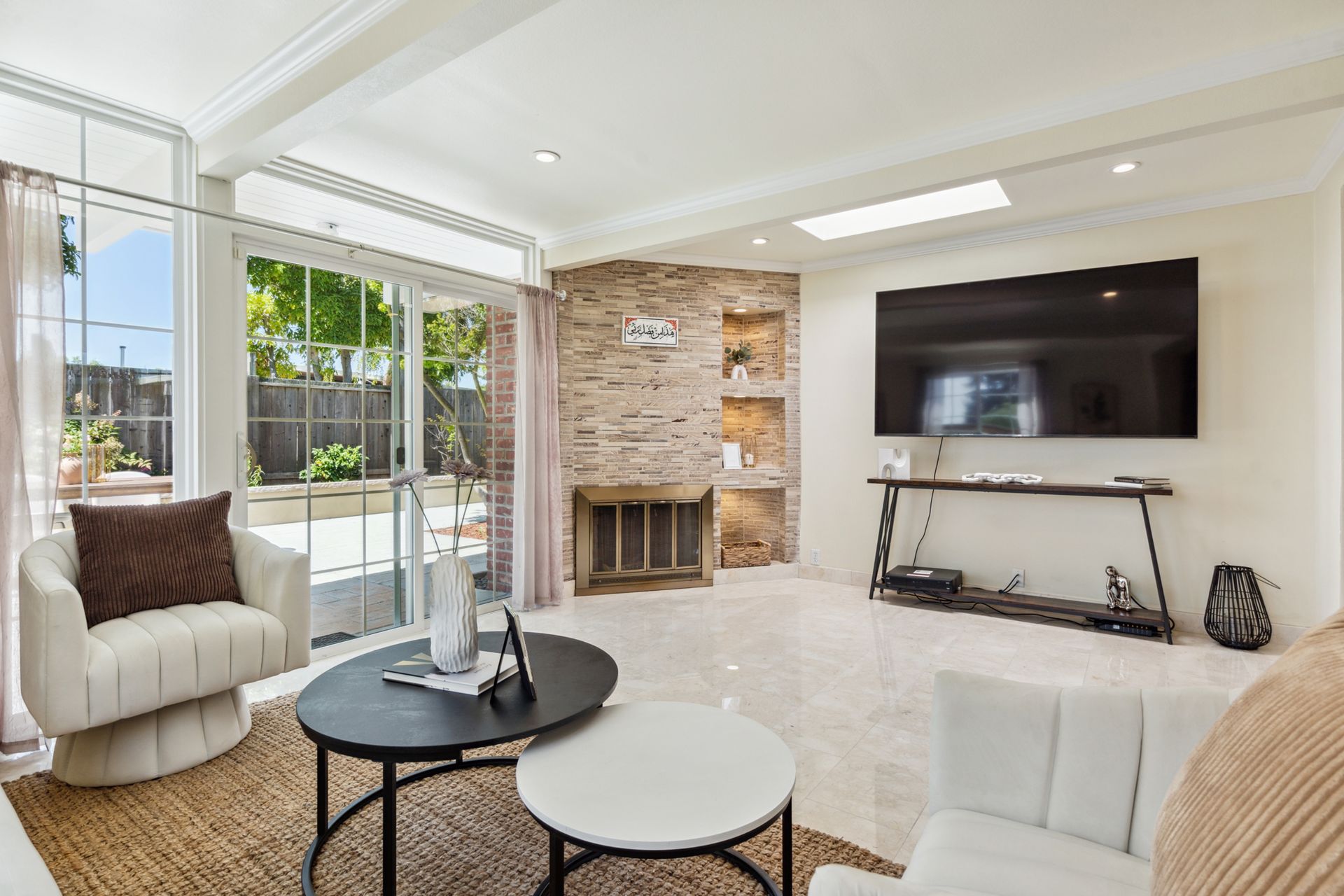 A living room with a couch , chair , table and television.
