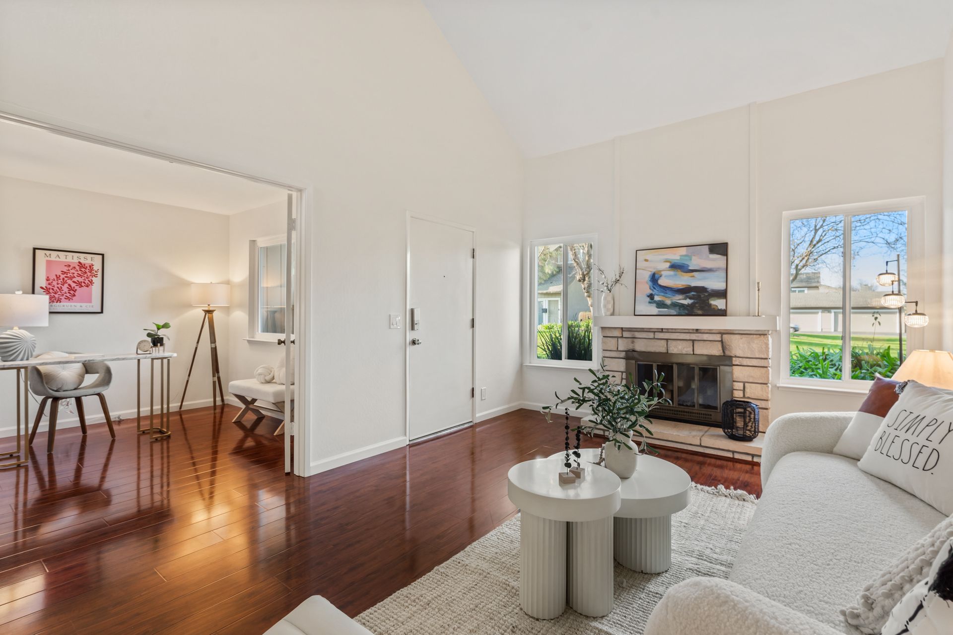 A living room with a couch , chair , table and fireplace.