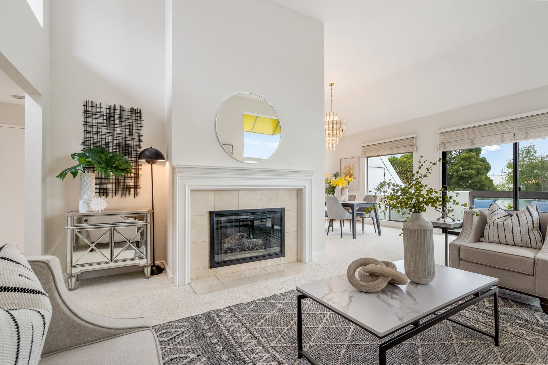 A living room with a fireplace , couch , coffee table and chairs.