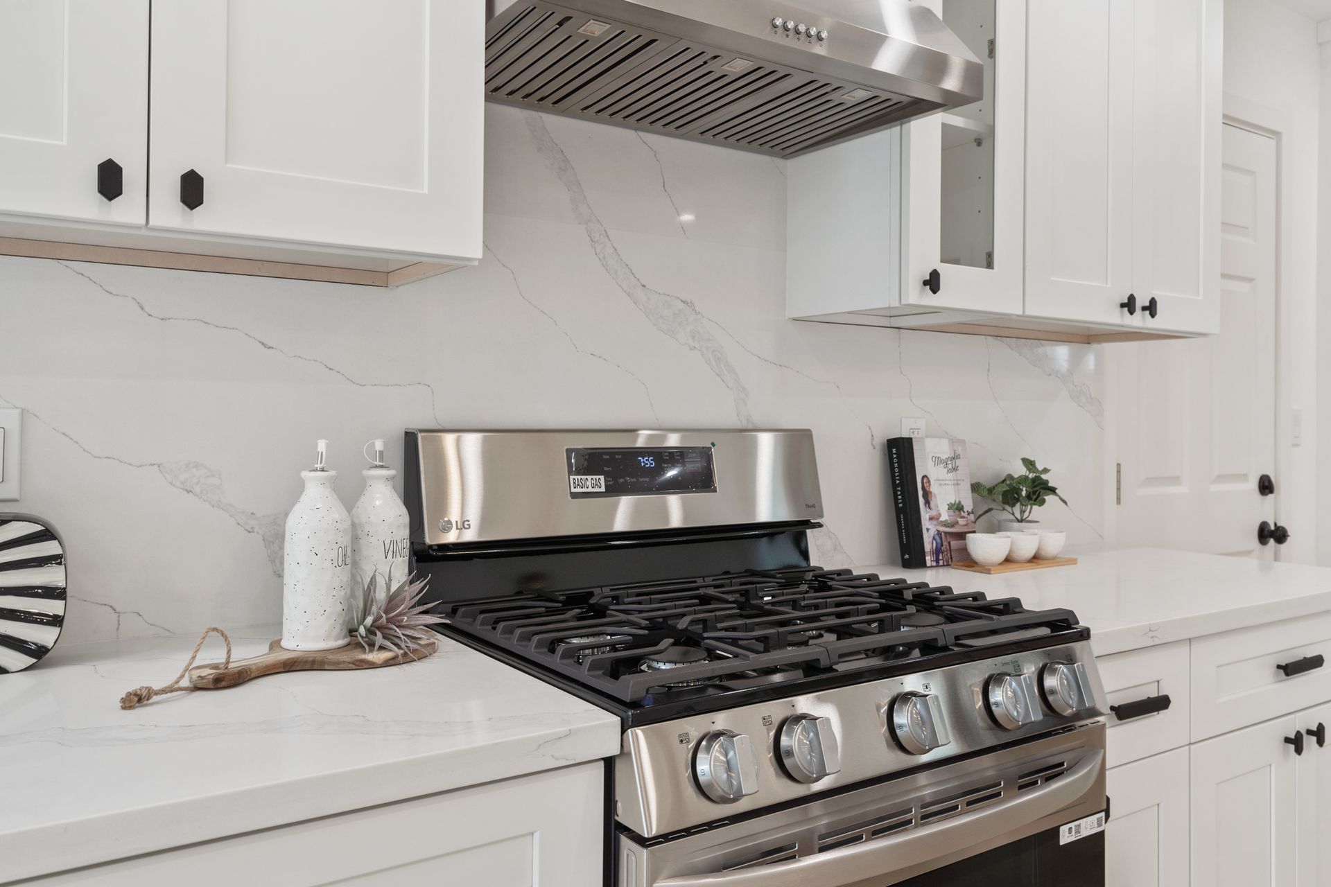 A stainless steel stove top oven is sitting on top of a white counter in a kitchen.