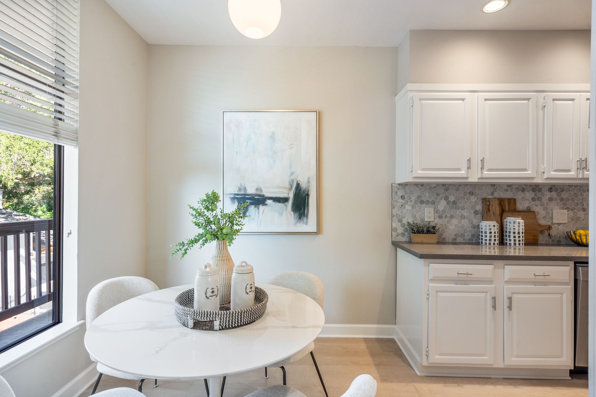 A kitchen with a table and chairs and a painting on the wall.