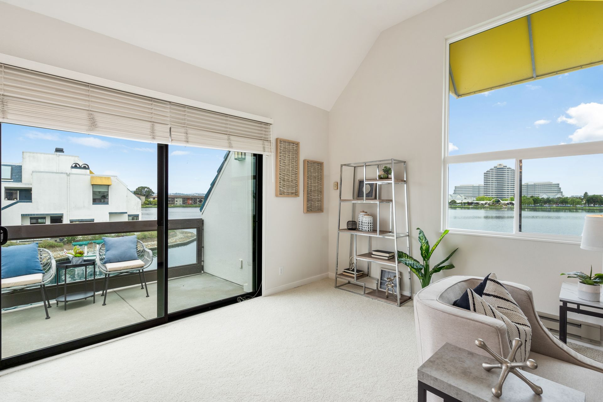 A living room with a balcony and a view of the water.