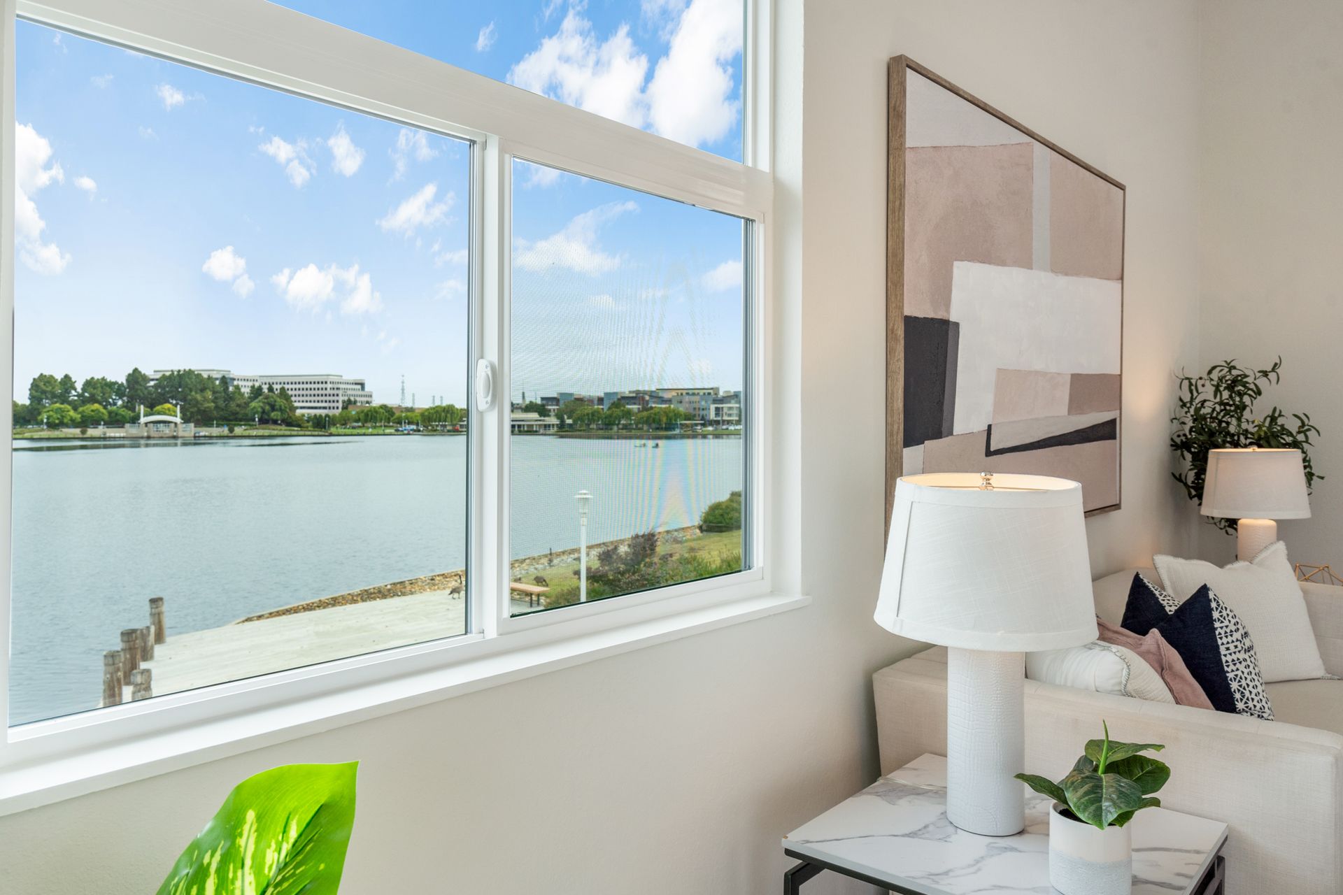 A living room with a large window overlooking a lake.