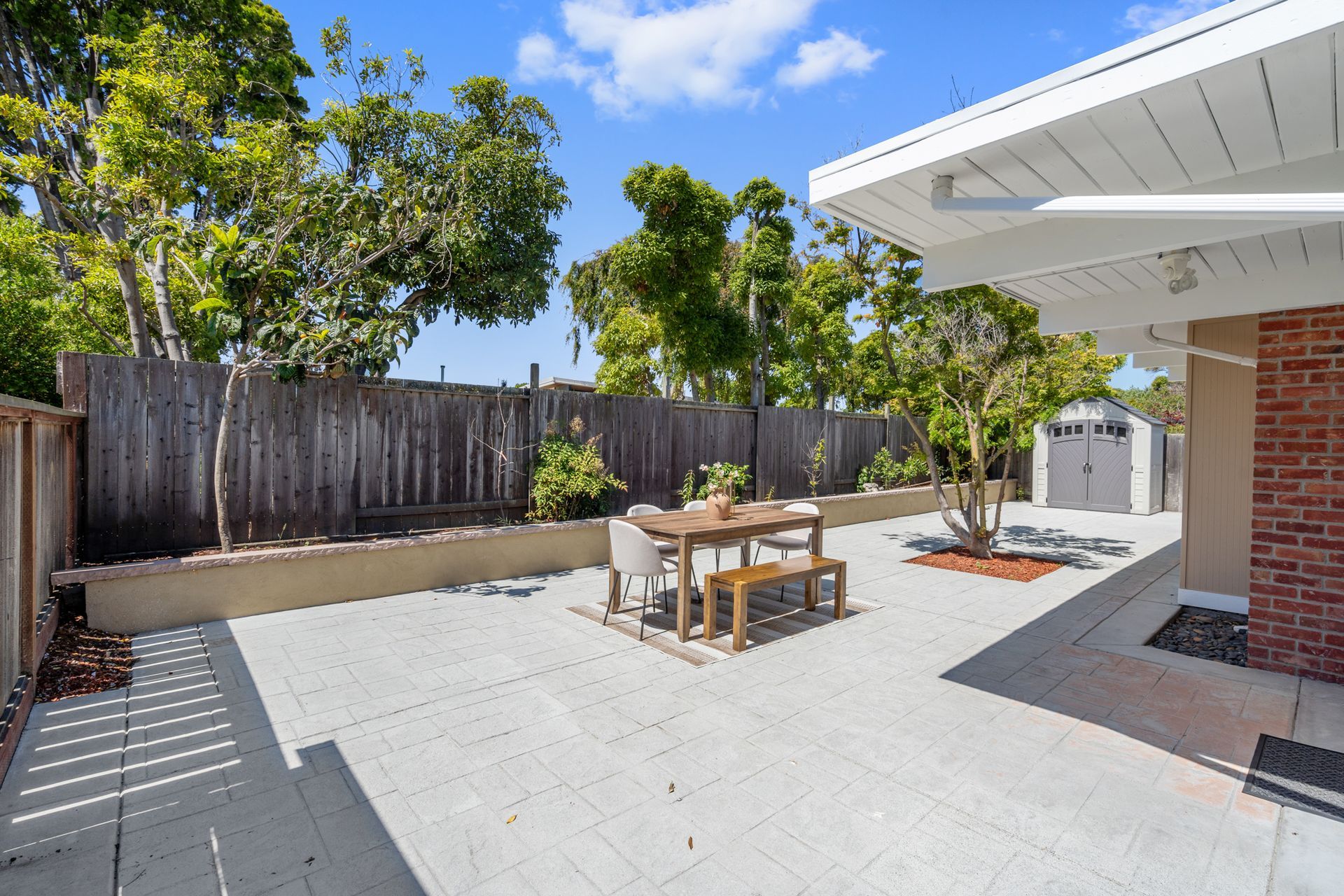 A patio with a table and chairs in front of a house