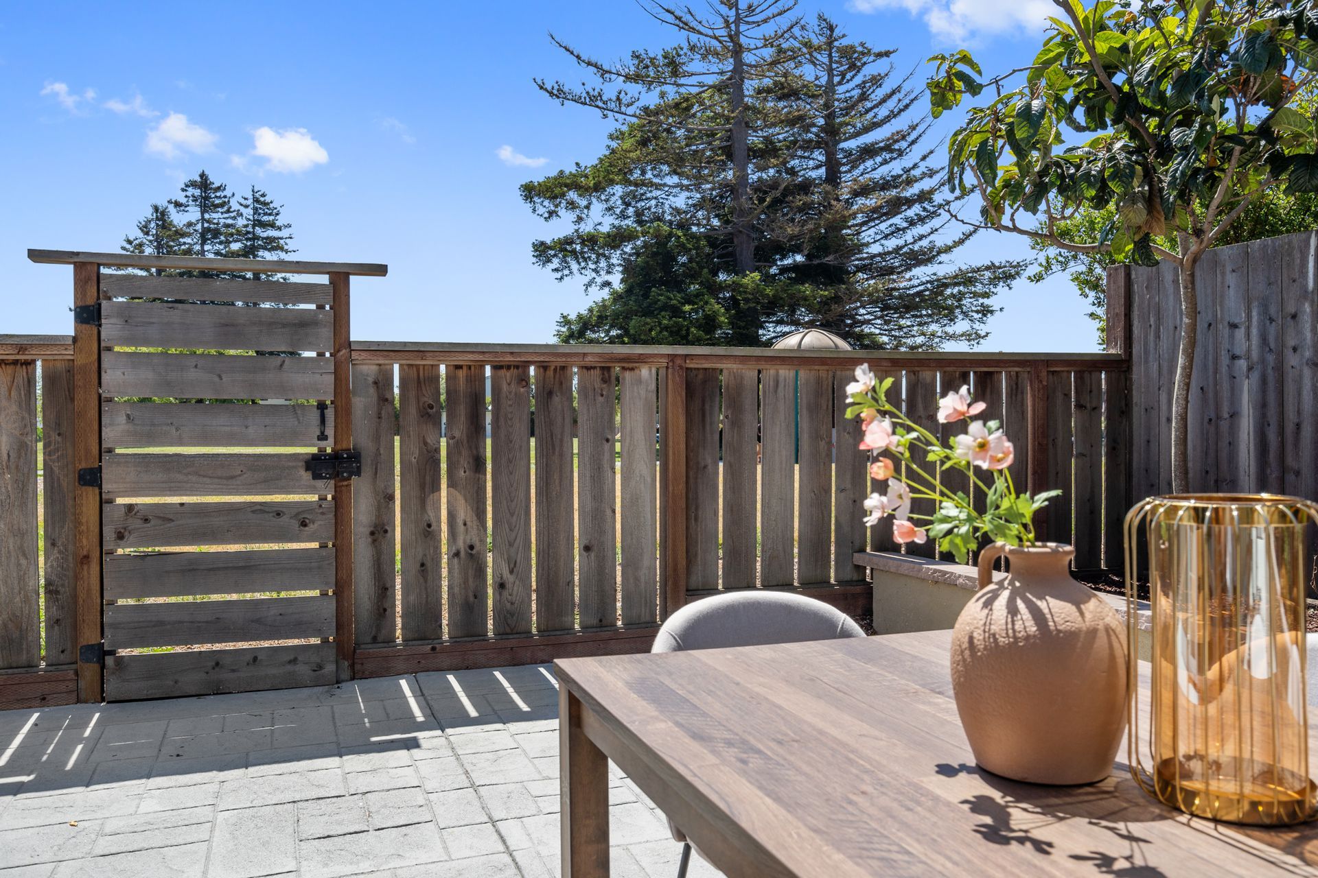 A wooden table with a vase of flowers on it