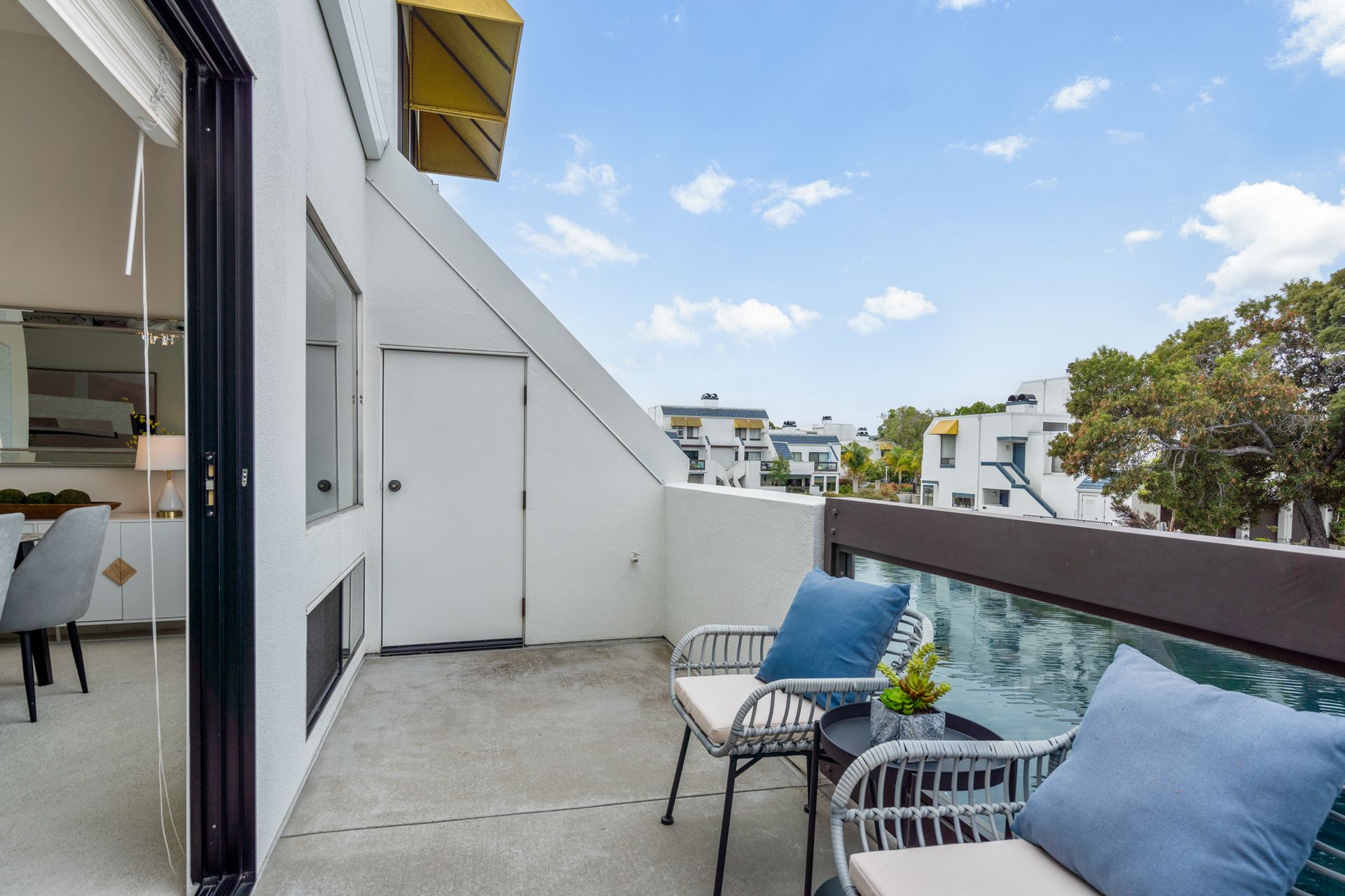 A balcony with a table and chairs and a view of a city.