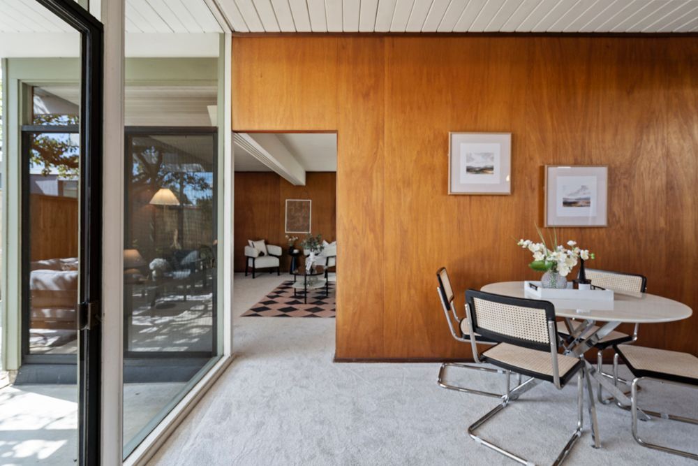 Open living and dining room with natural light, fireplace, and glass doors — Rumana Jabeen & Associates highlight flow and atmosphere buyers value and sellers can showcase.