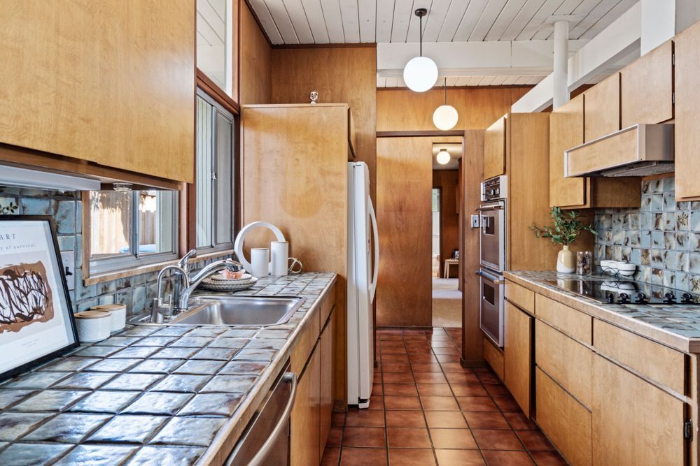 Galley kitchen with wood cabinetry and vintage charm, represented by Rumana Jabeen & Associates to appeal to buyers seeking character and assure sellers of thoughtful presentation.