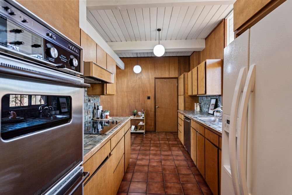 Galley kitchen with wood cabinetry and vintage charm, represented by Rumana Jabeen & Associates to appeal to buyers seeking character and assure sellers of thoughtful presentation.