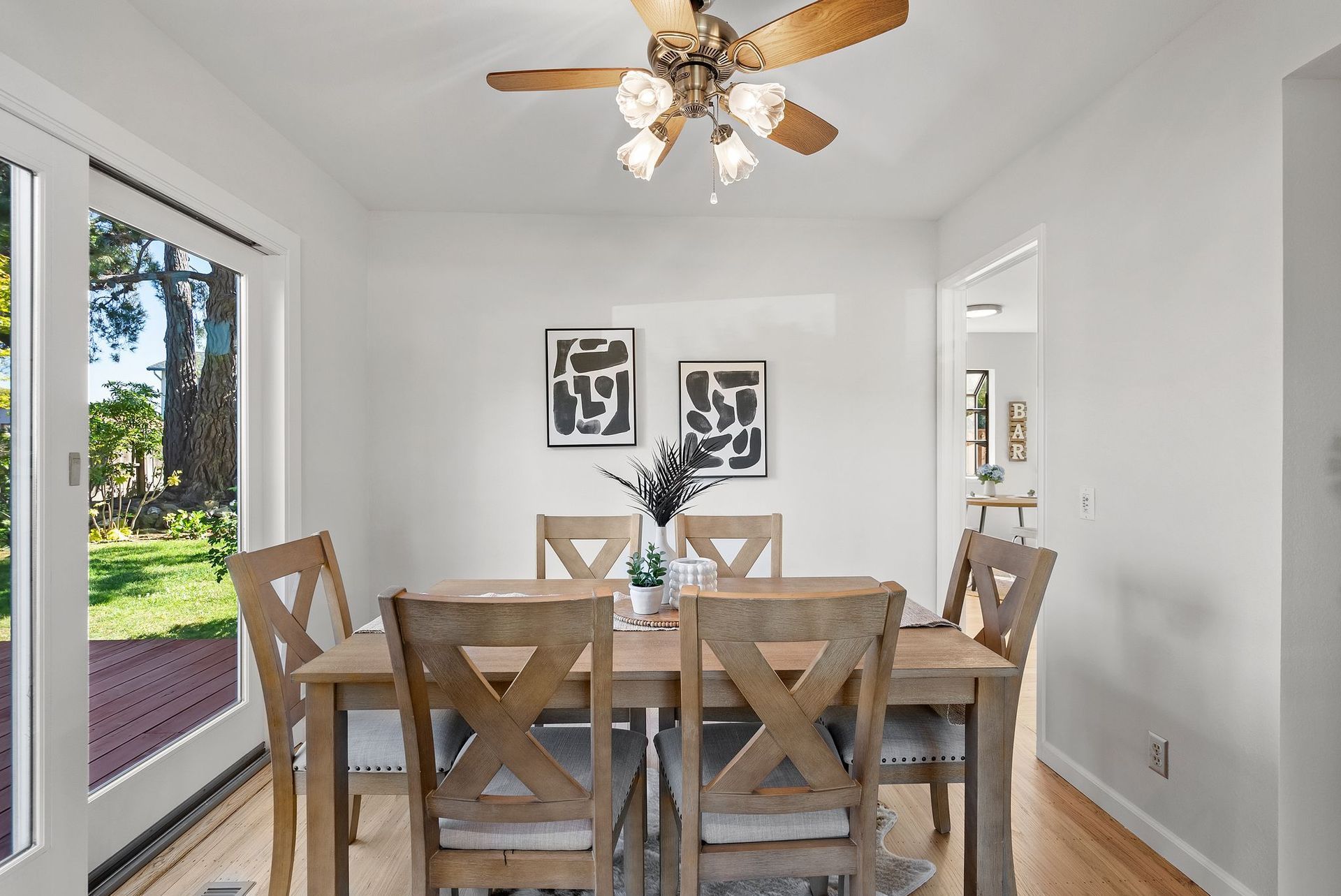 A dining room with a table and chairs and a ceiling fan.