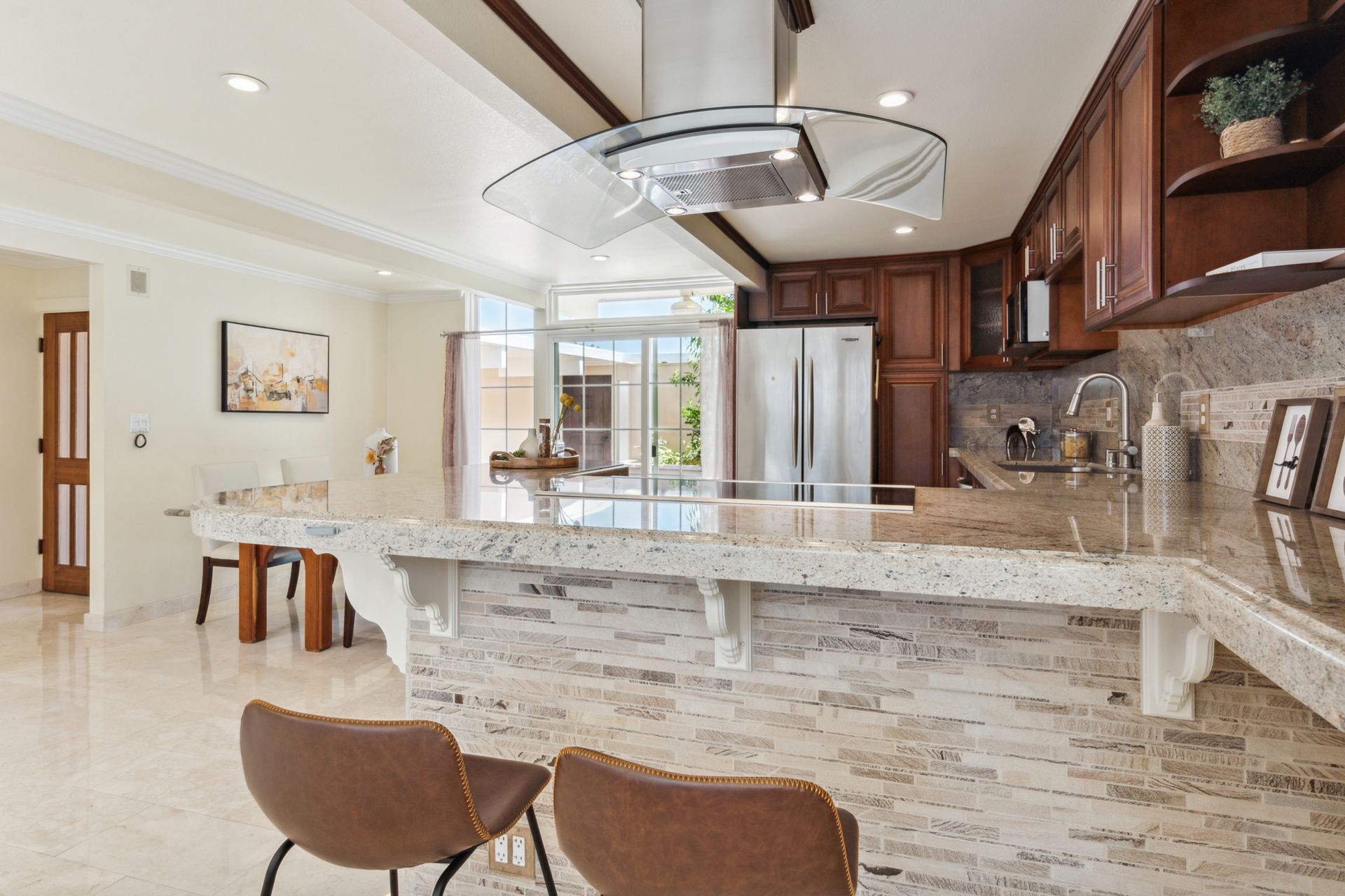 A kitchen with a large island and a refrigerator.