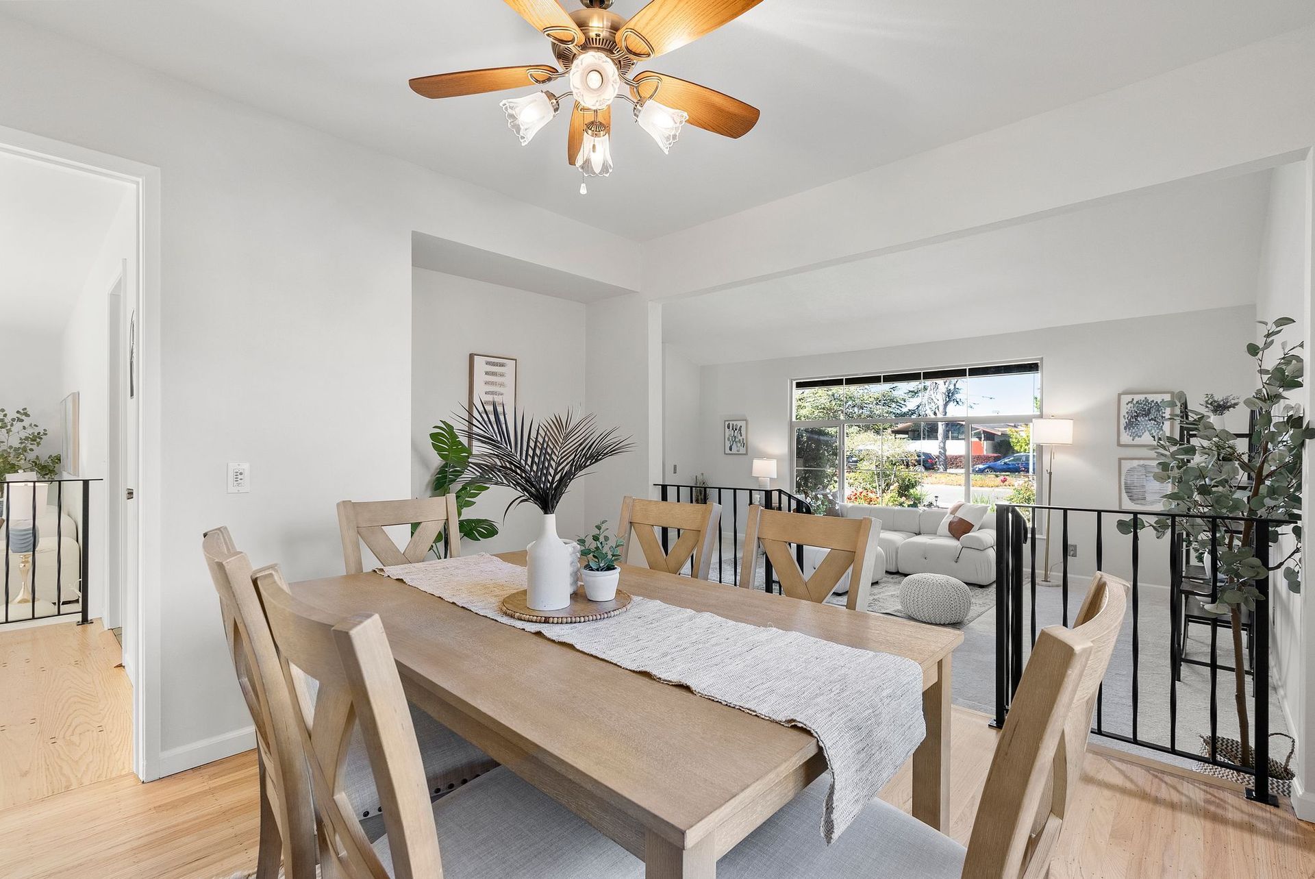 A dining room with a table and chairs and a ceiling fan.