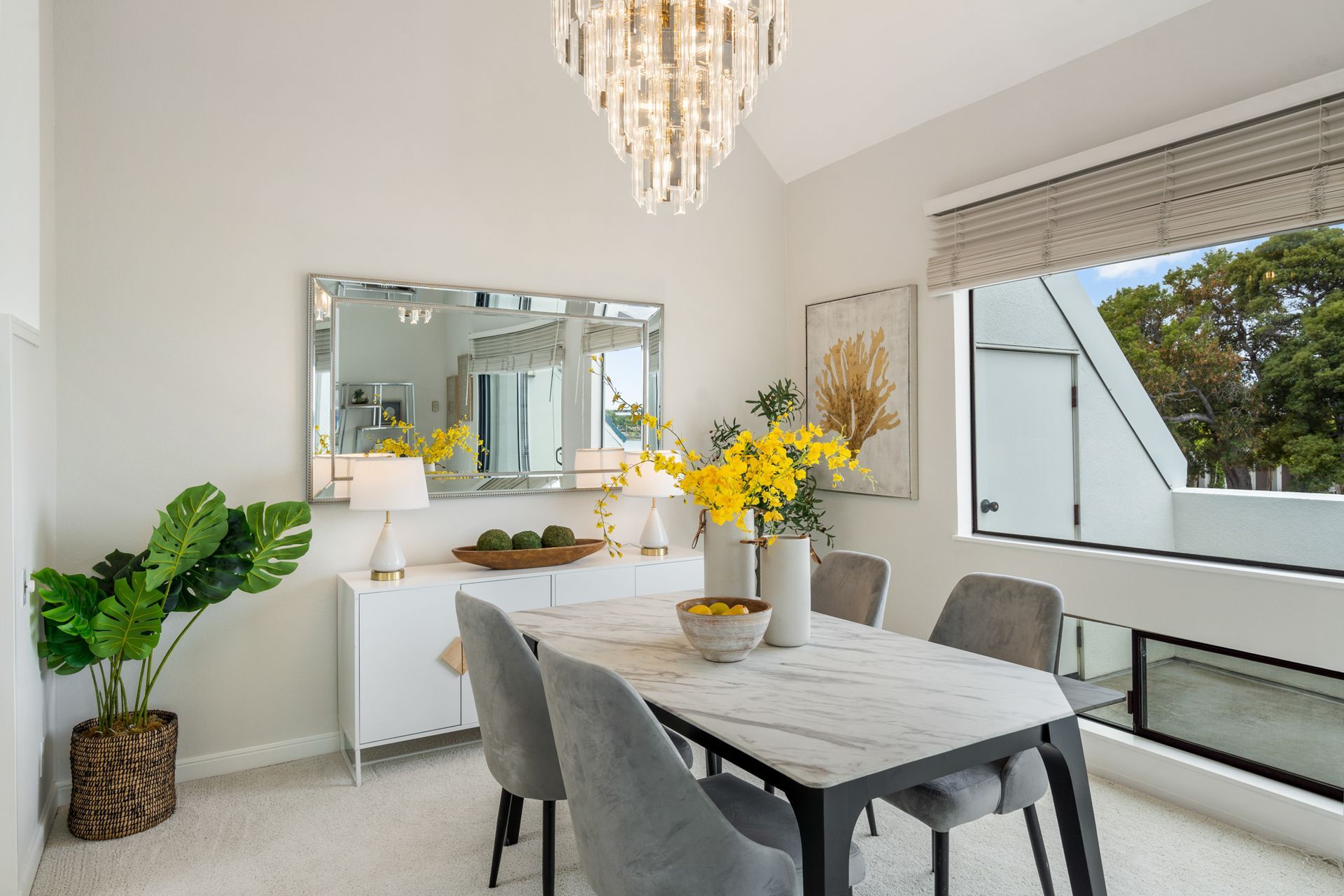 A dining room with a table and chairs and a chandelier.
