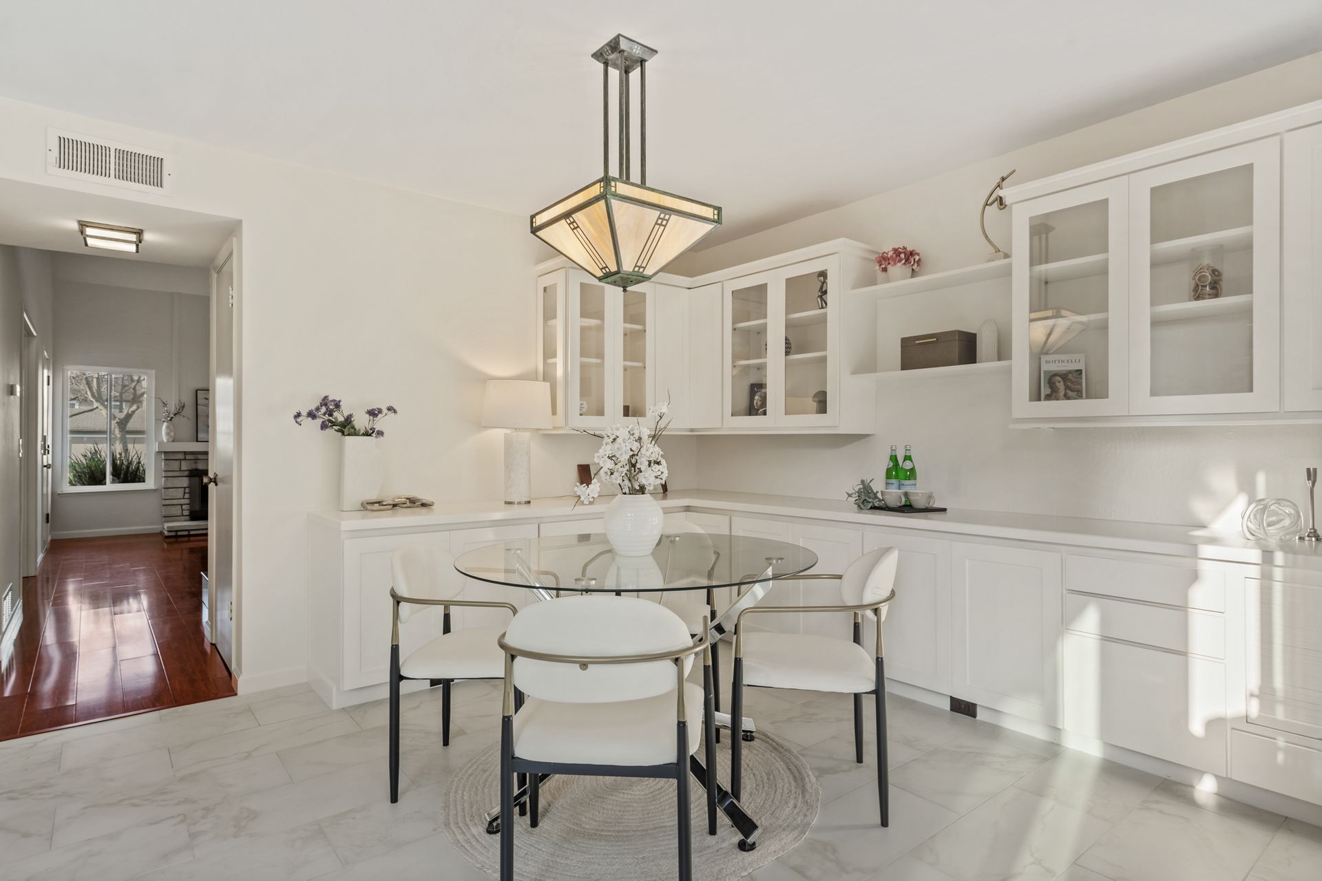 A dining room with a table and chairs and a chandelier hanging from the ceiling.