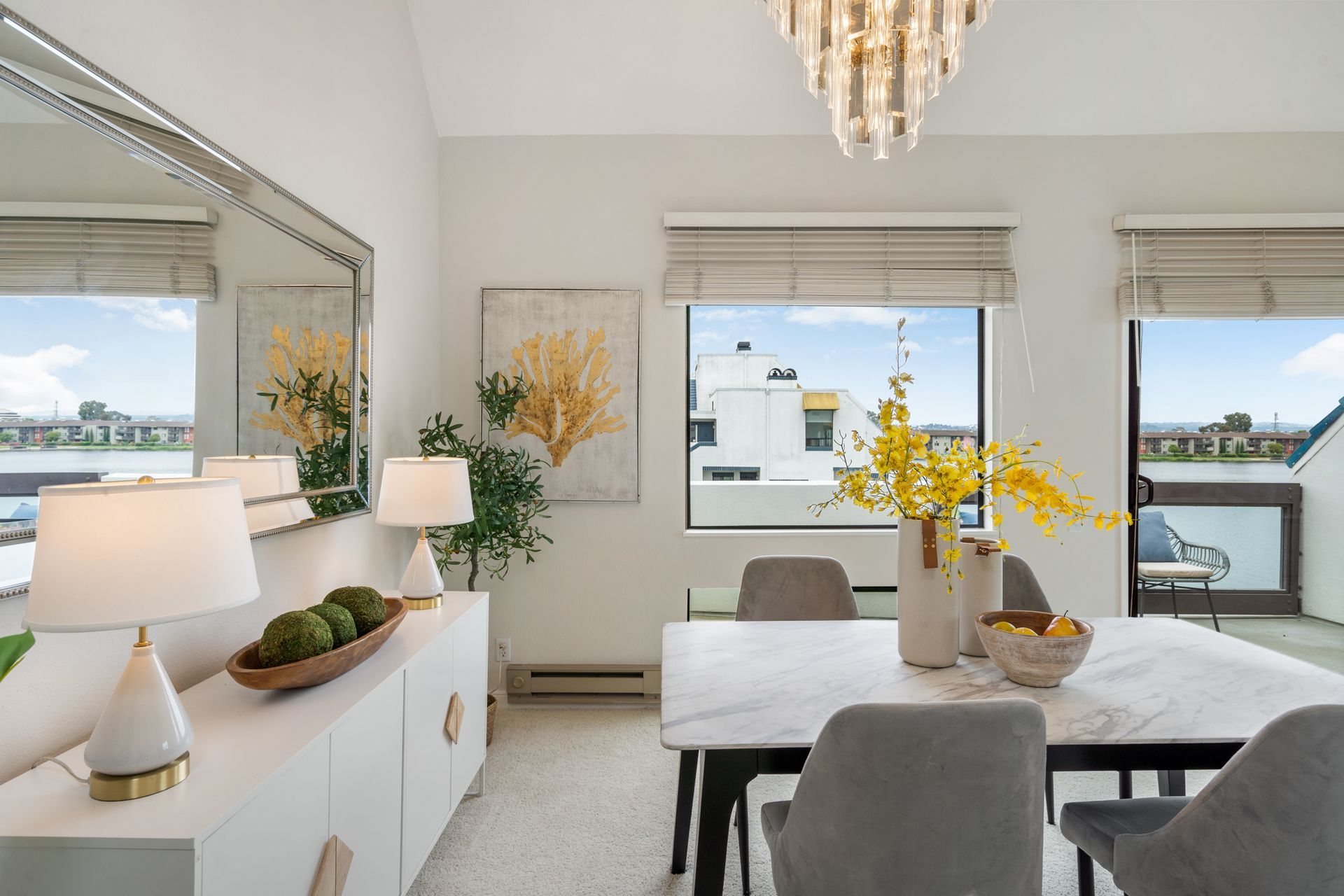 A dining room with a table and chairs and a large mirror.