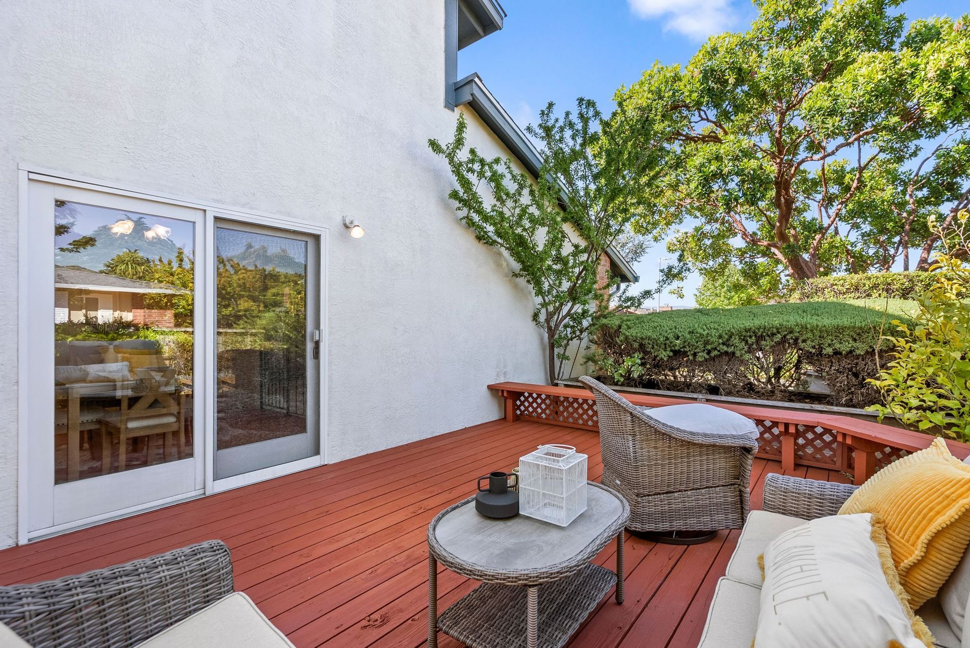 A wooden deck with a couch , chairs and a table