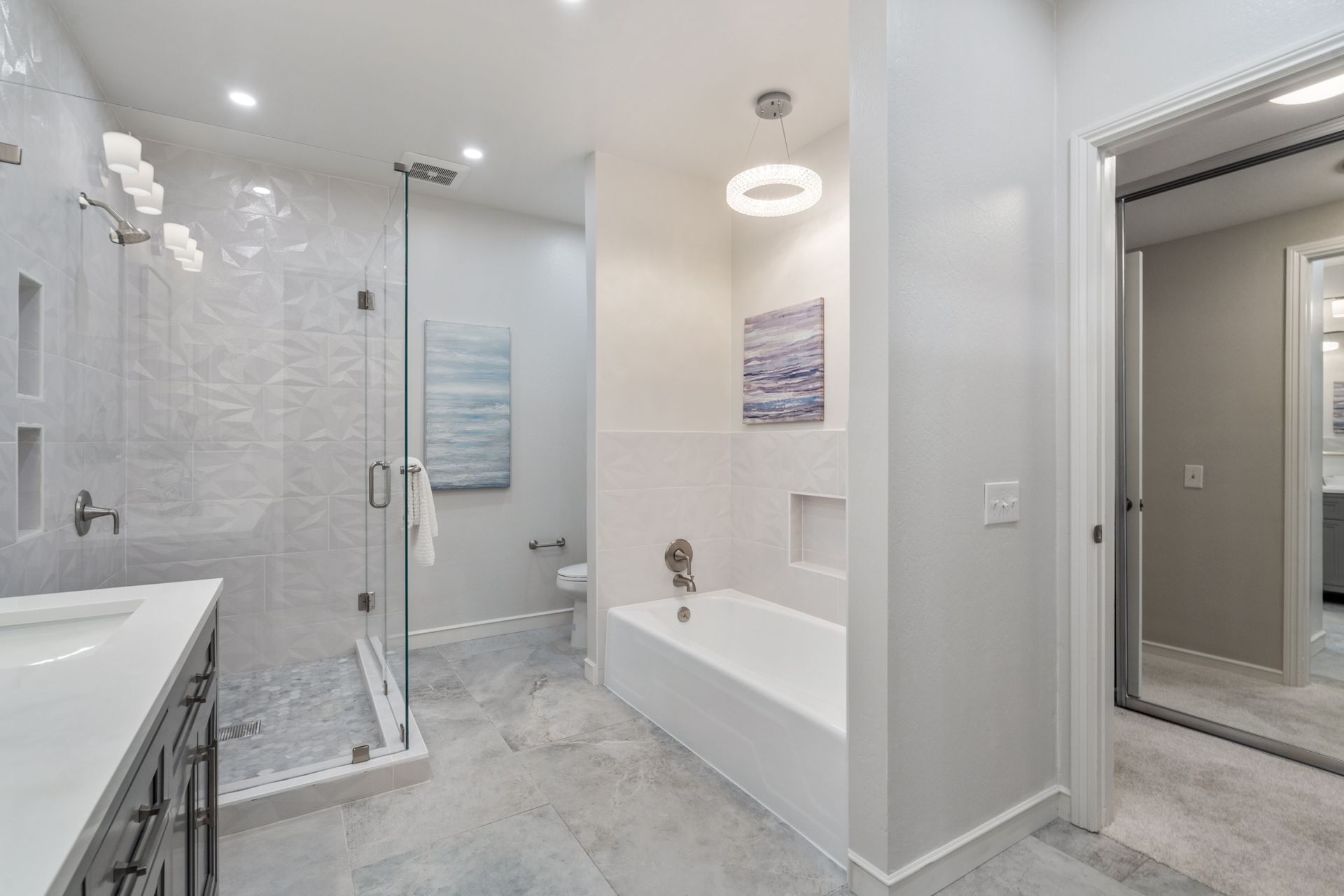 A bathroom with a tub , shower , sink and mirror.