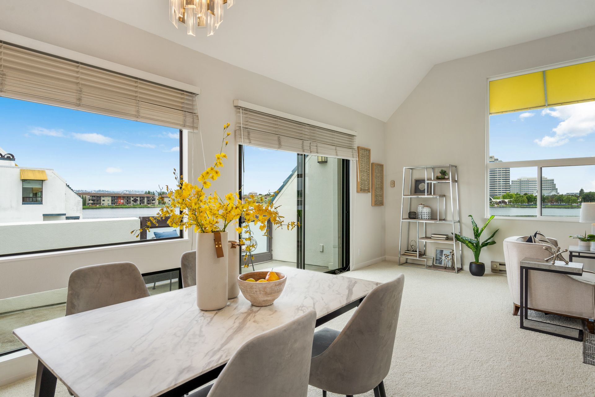 A living room with a dining table and chairs and a large window.