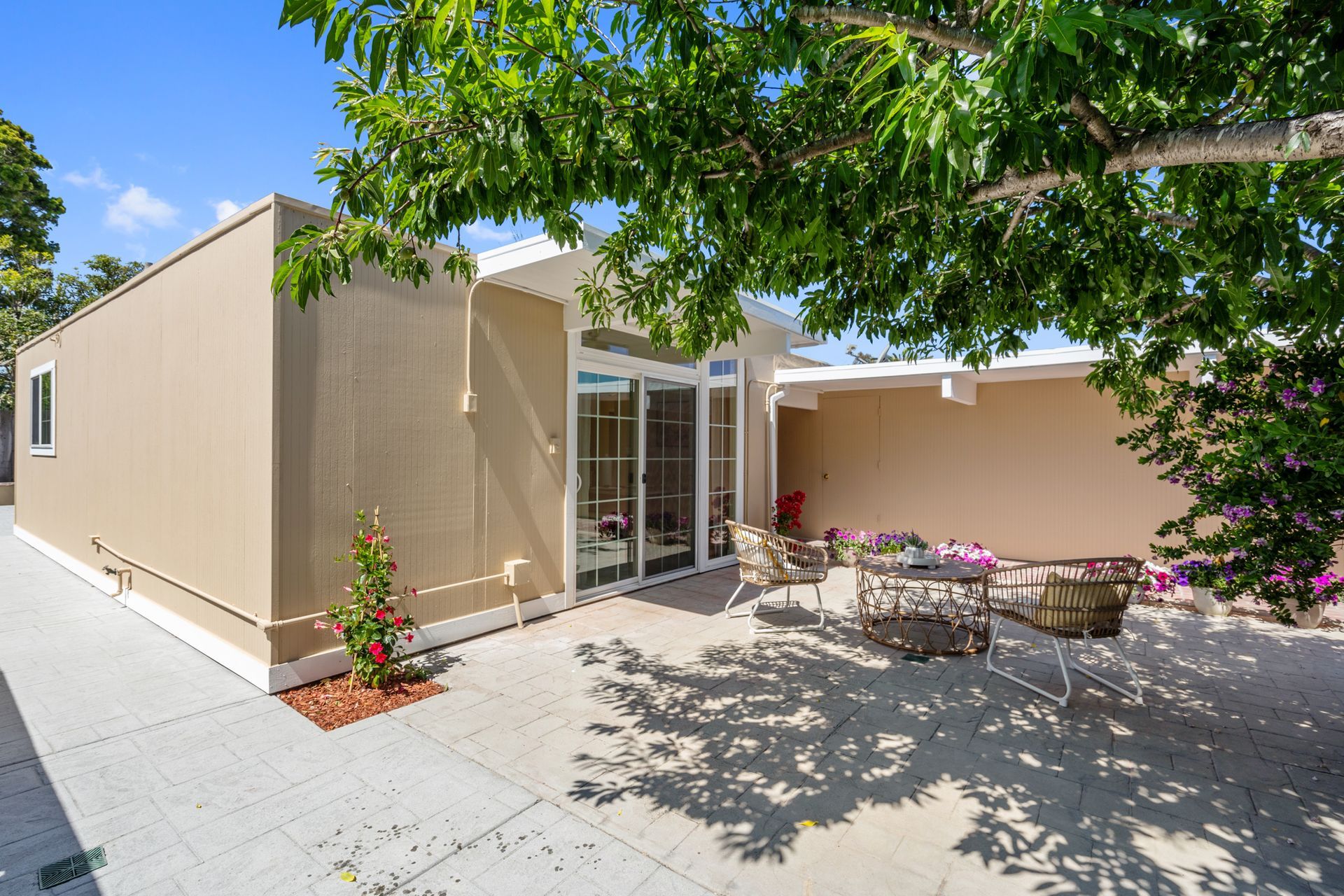 A house with a patio and a tree in front of it