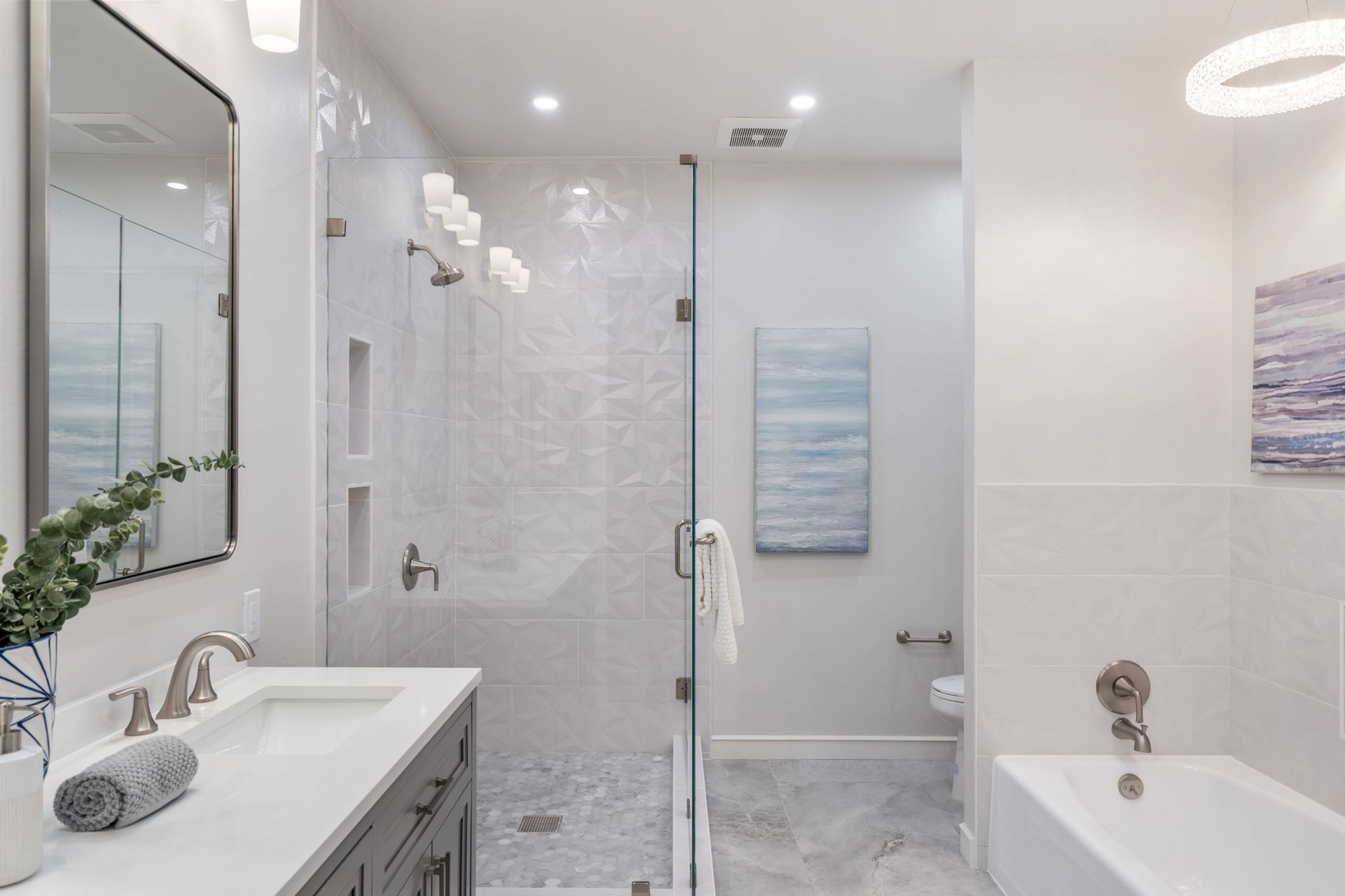 A bathroom with a tub , sink , mirror and walk in shower.