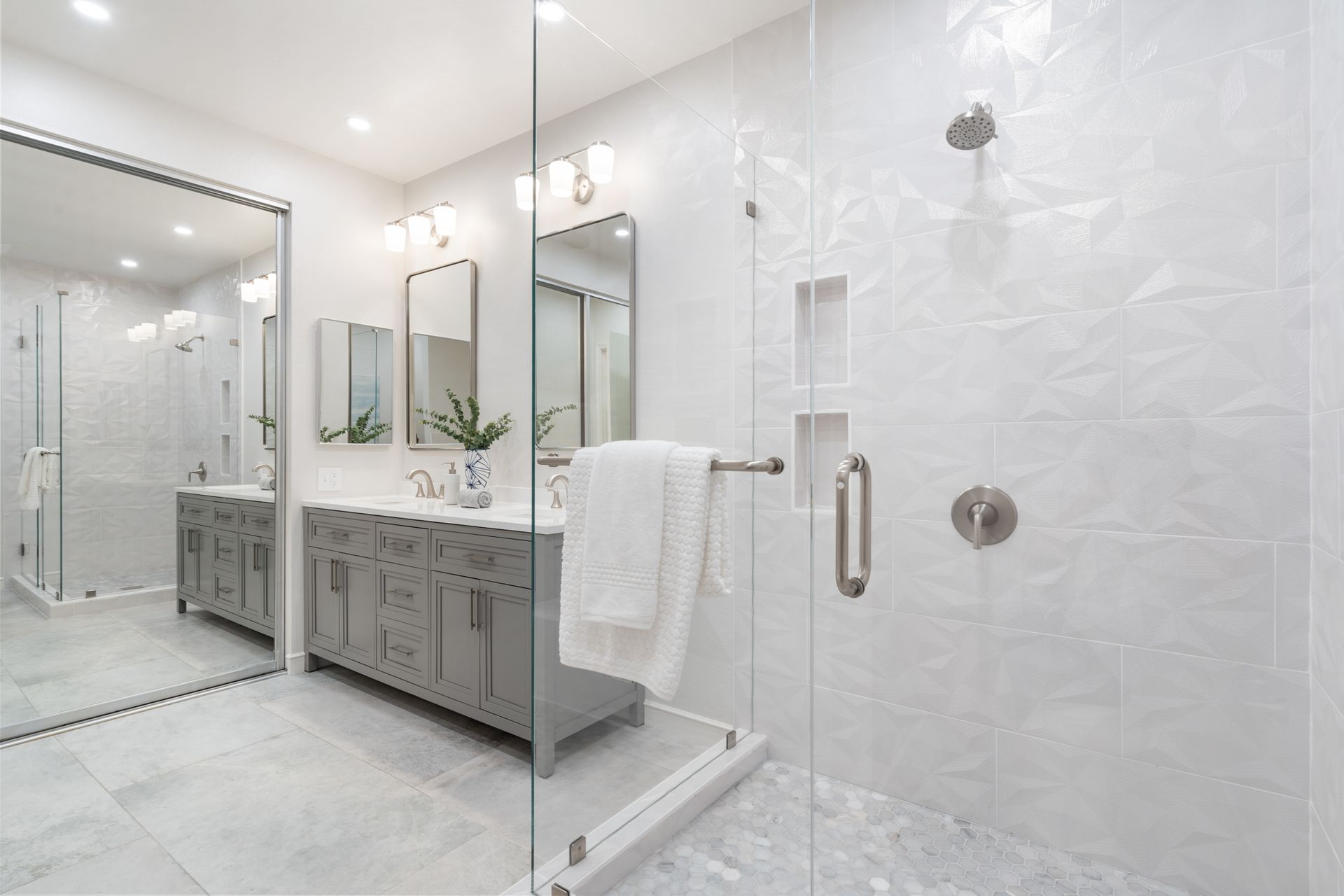 A bathroom with two sinks and a walk in shower.